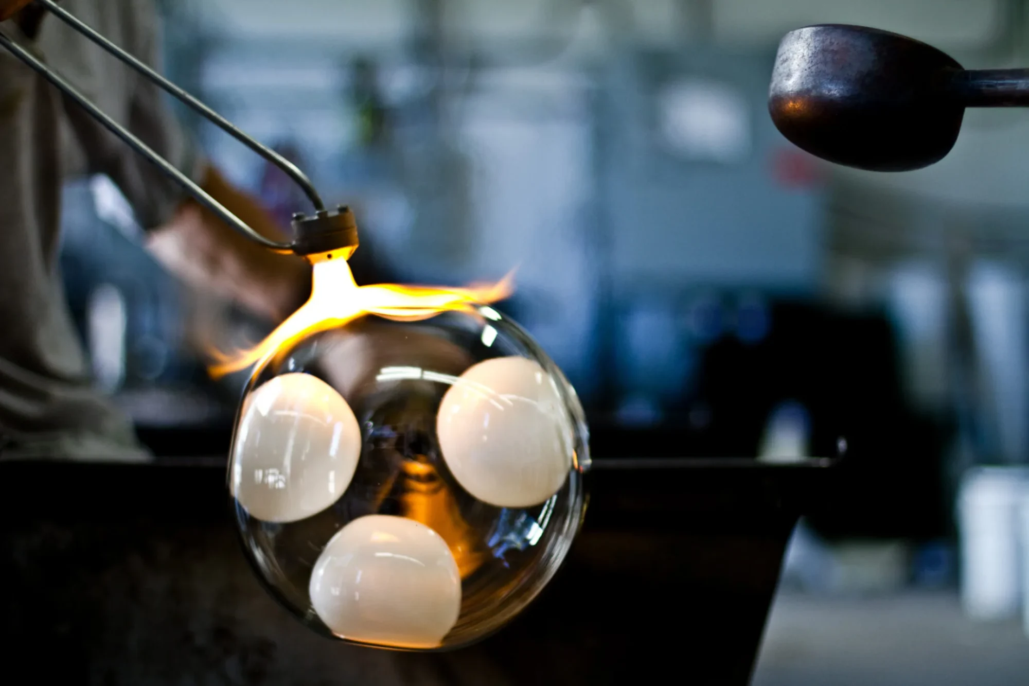 Hot glass being worked with tongs in the Bocci glass workshop