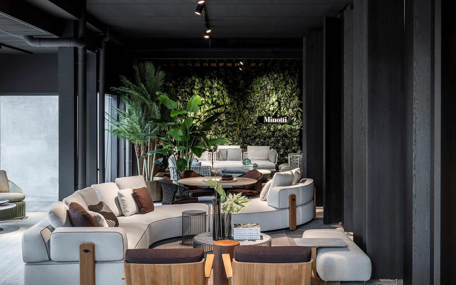 Minotti lounge sofa and armchairs in a dark, plant-filled interior