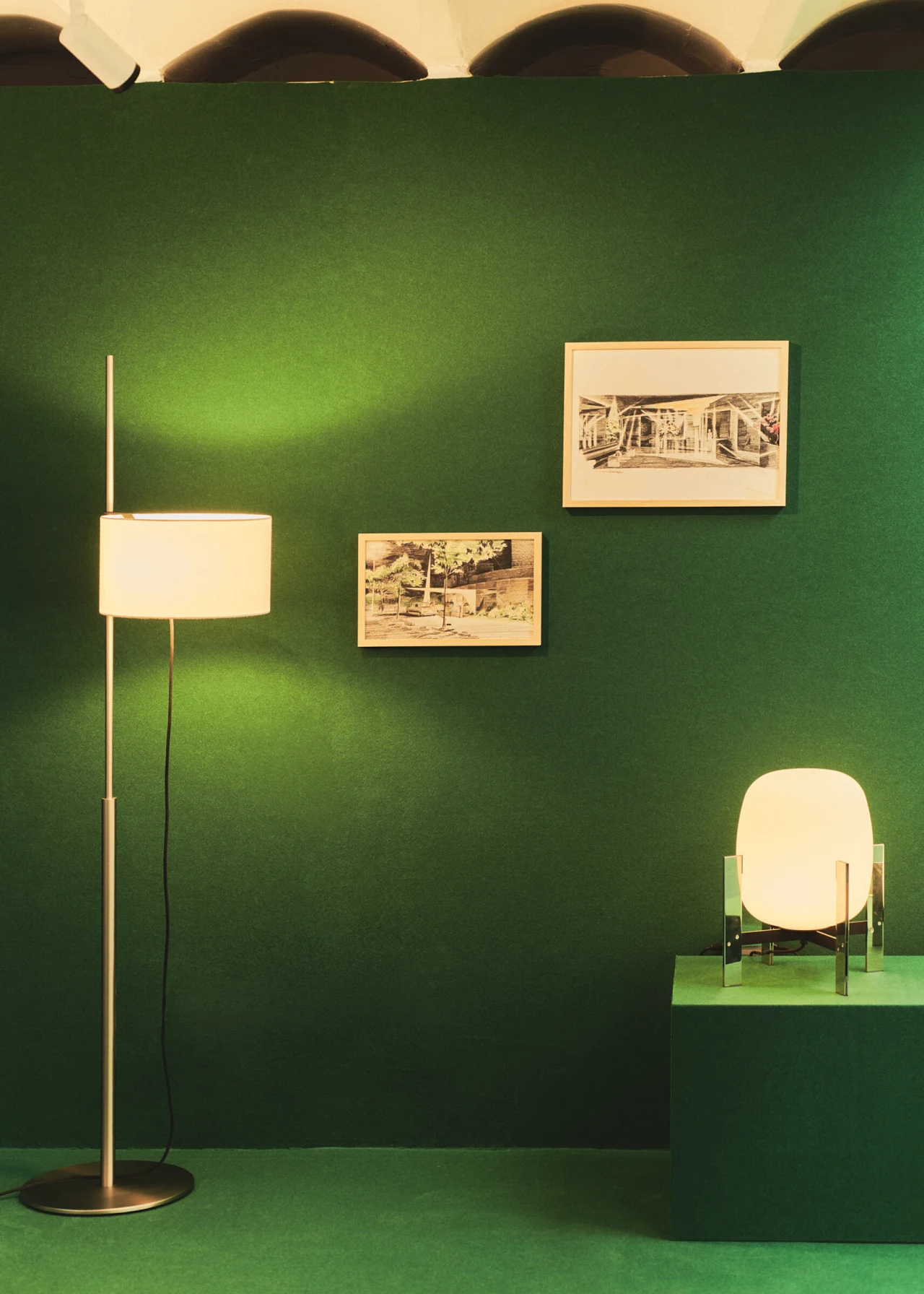 Santa & Cole floor lamp and table lamp on a green display wall
