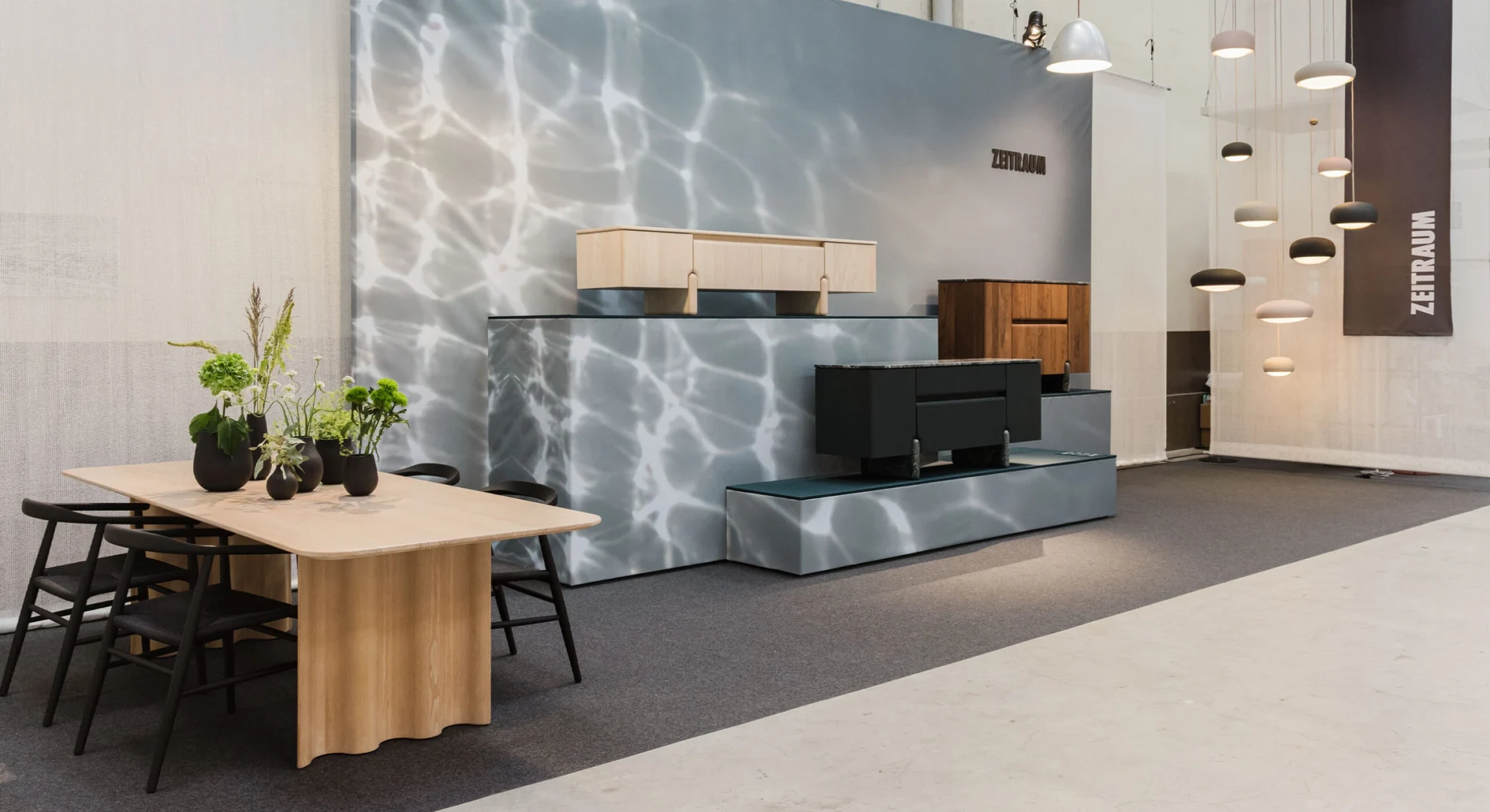 Zeitraum stand with a wooden table, sideboards and pendant lamps