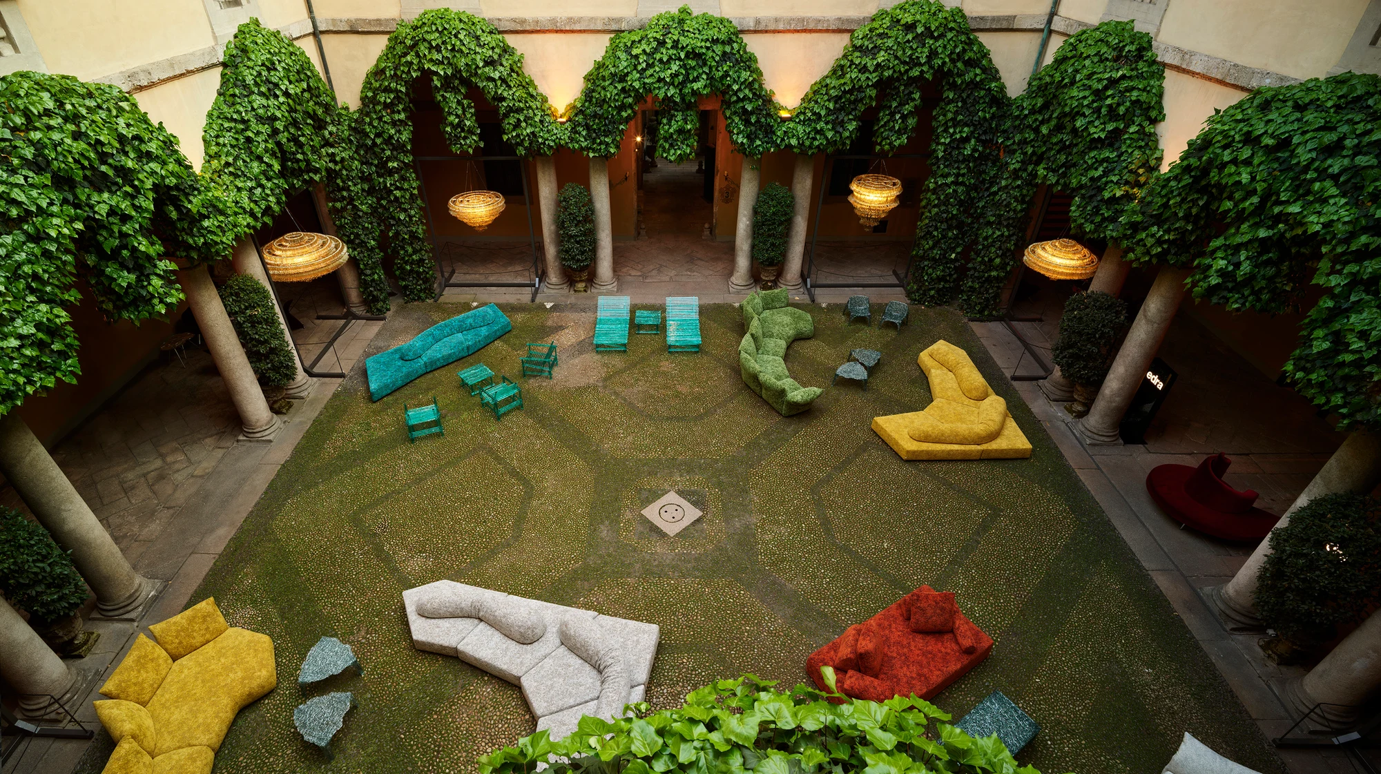 Edra sofas arranged in an ivy-covered courtyard at Palazzo Durini