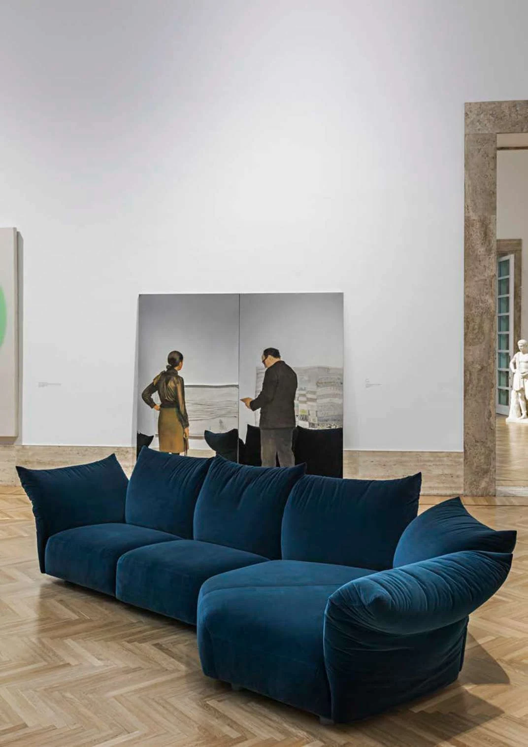 Blue sofa with soft armrests in a museum gallery