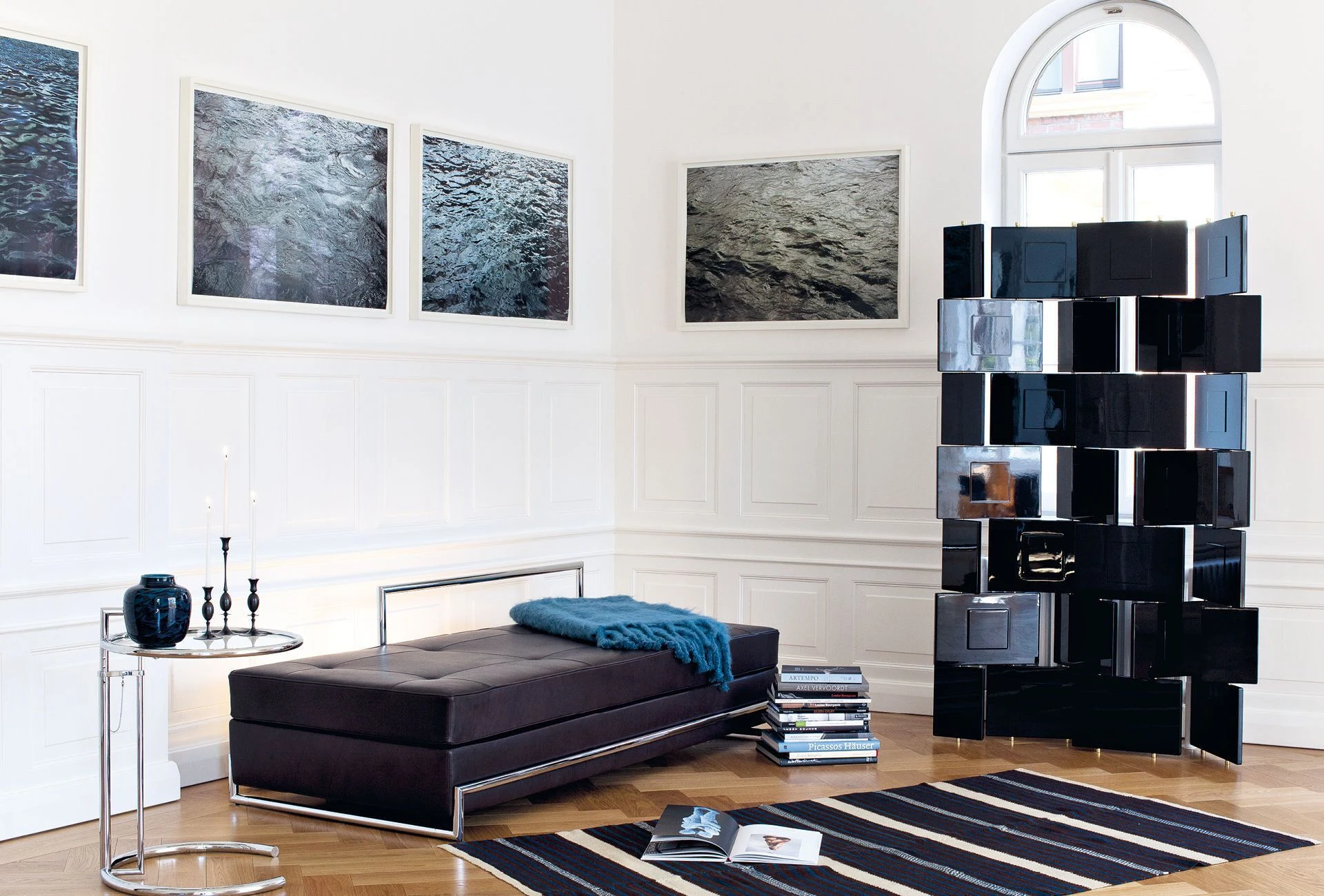 The Day Bed in a white room with a screen, a small table and a rug