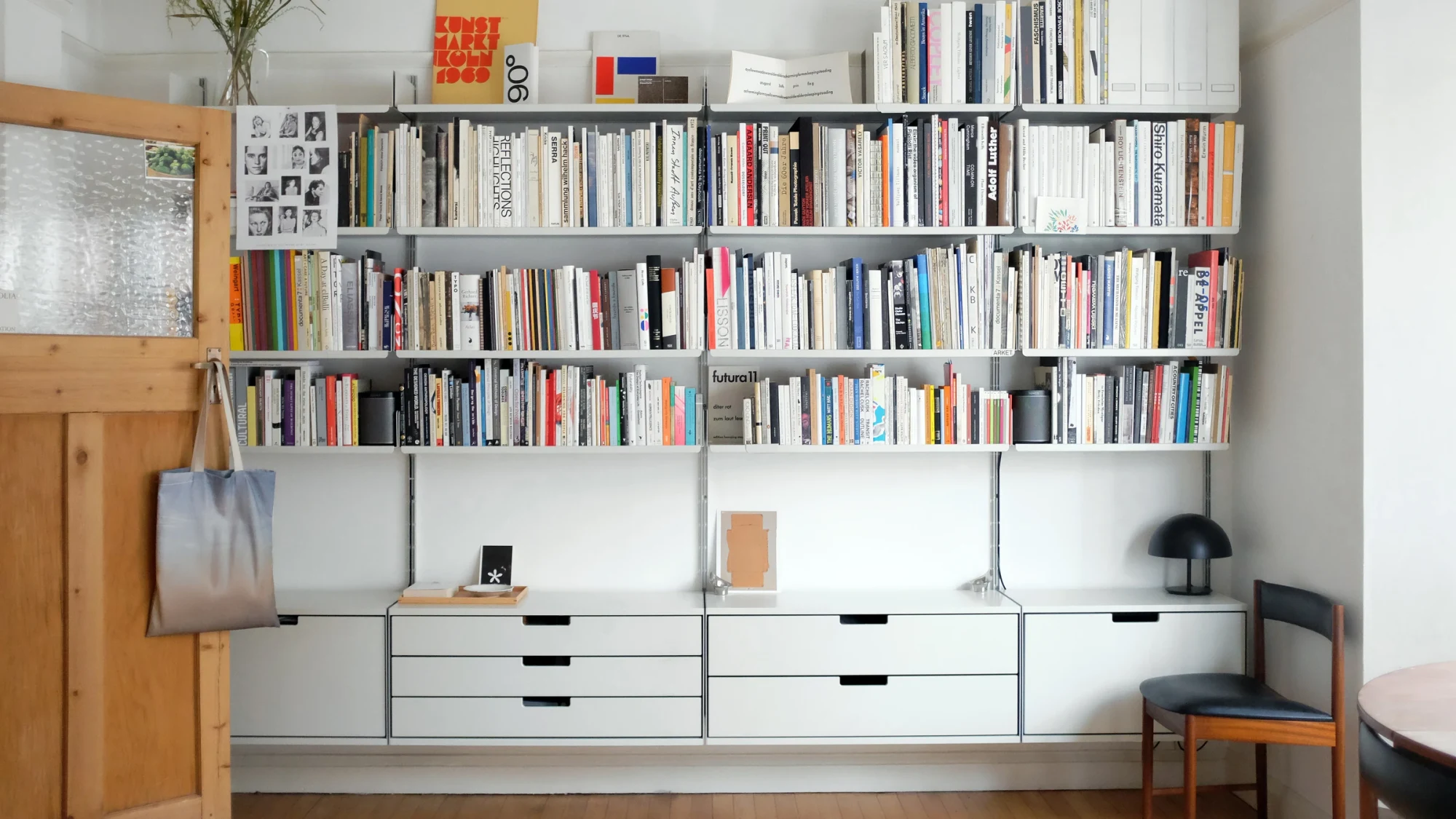 Vitsœ wall-mounted shelving with books and drawers in a home