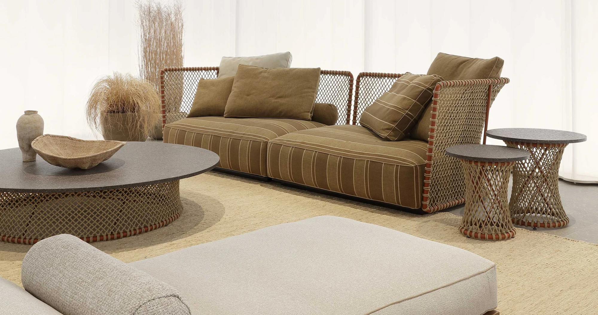 Sofa, round coffee table and side tables in a Flexform setting