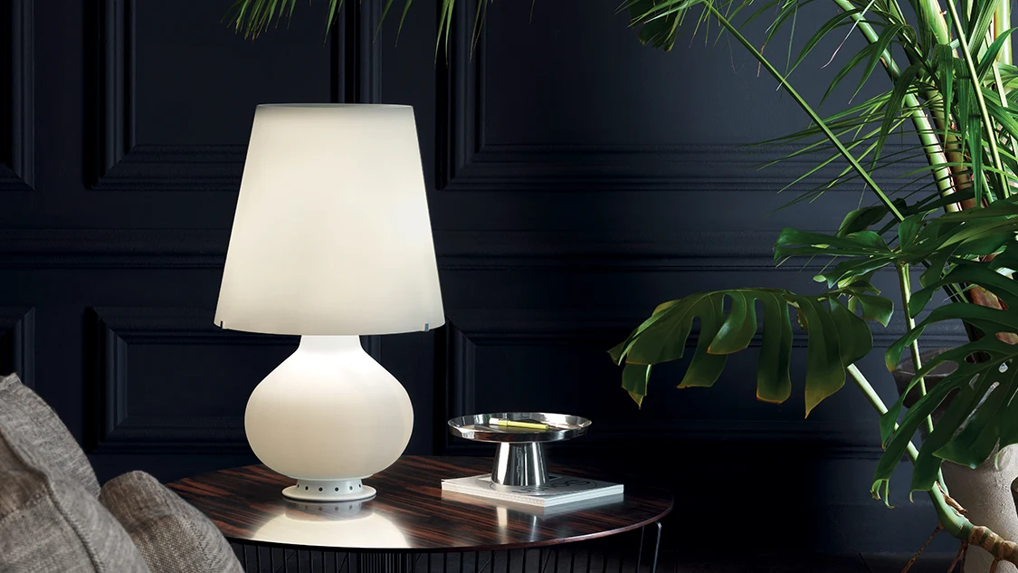 Table lamp with a white glass shade in a dark interior