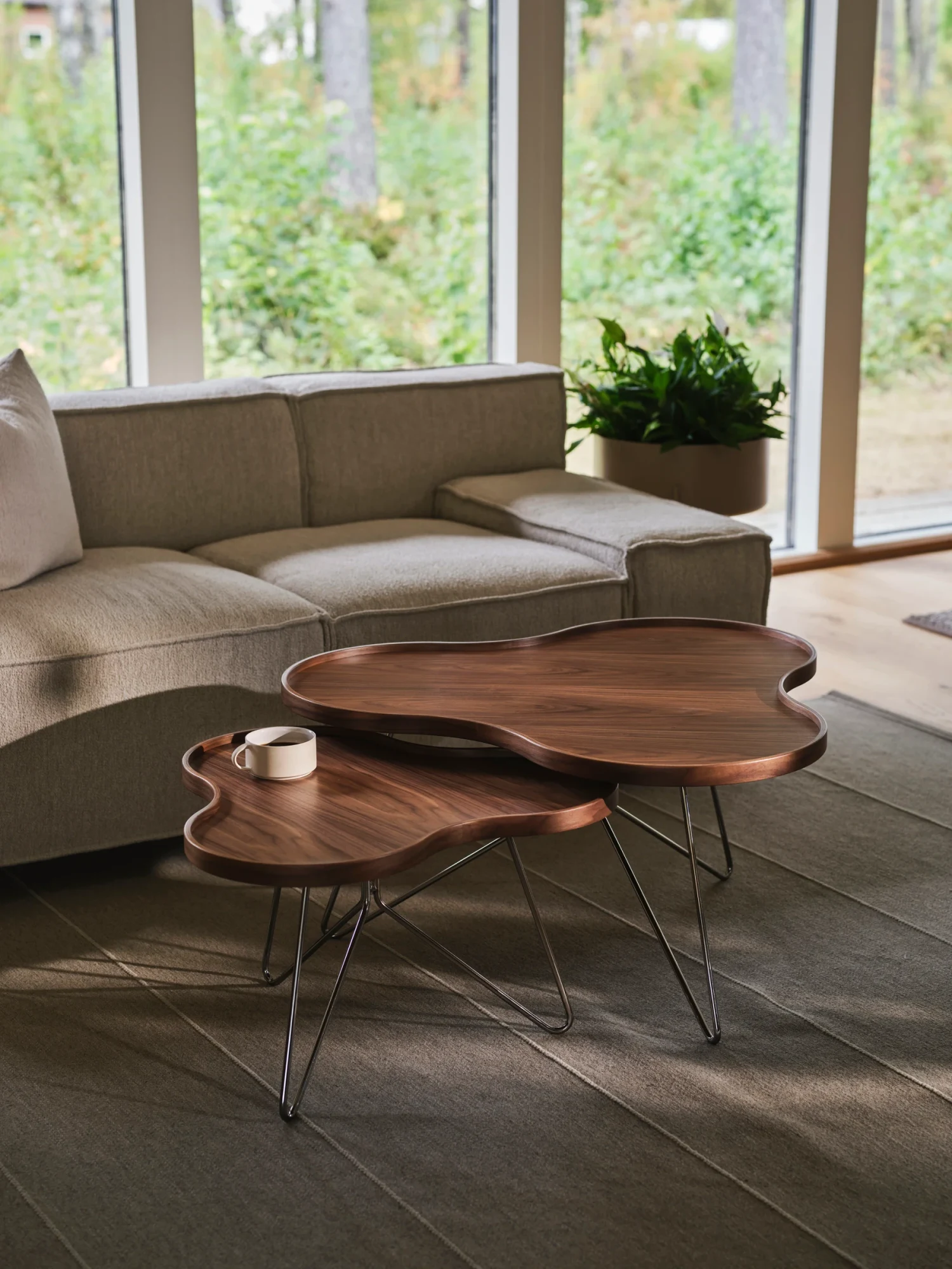 Swedese sofa and wooden coffee tables in a room with large windows