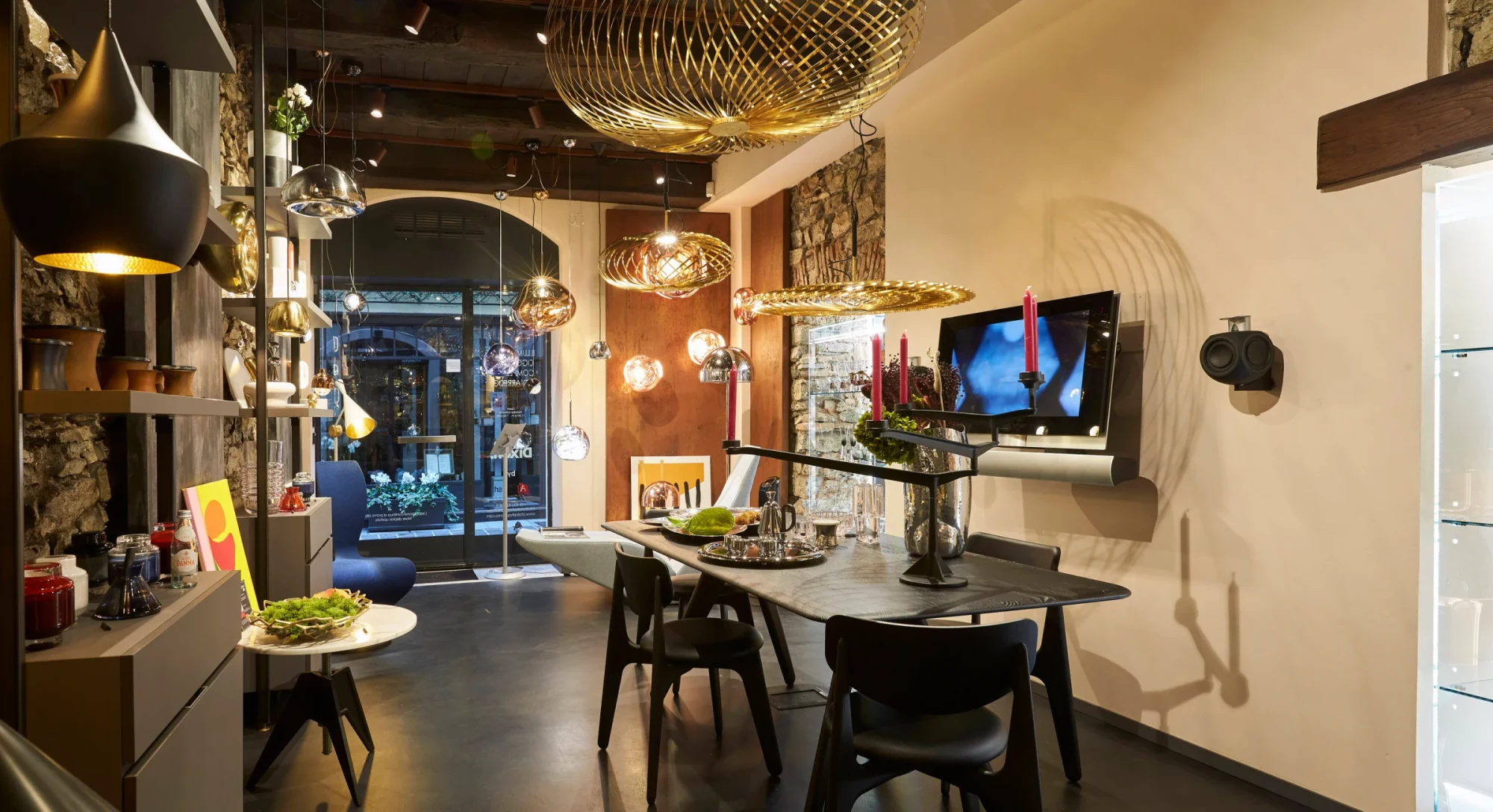 Tom Dixon store interior with brass pendant lights and a dining table