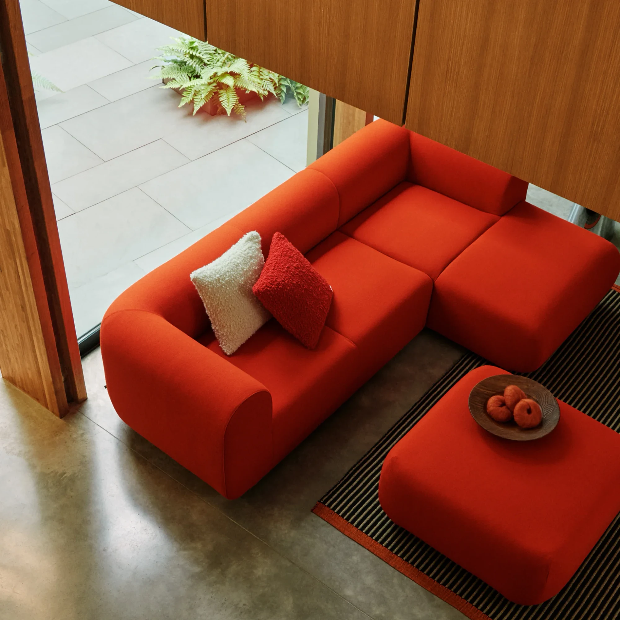 Tom Dixon red modular sofa and ottoman in a room with a terrace
