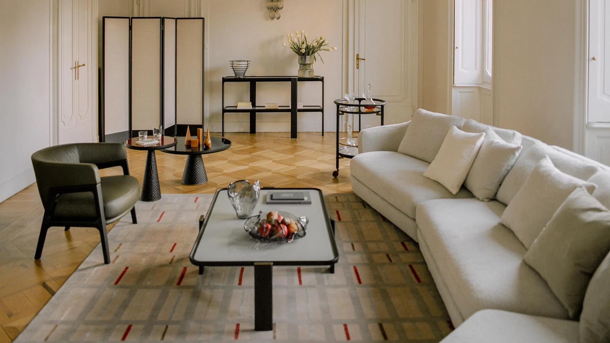 Living room with a sofa, a low table, an armchair and a folding screen