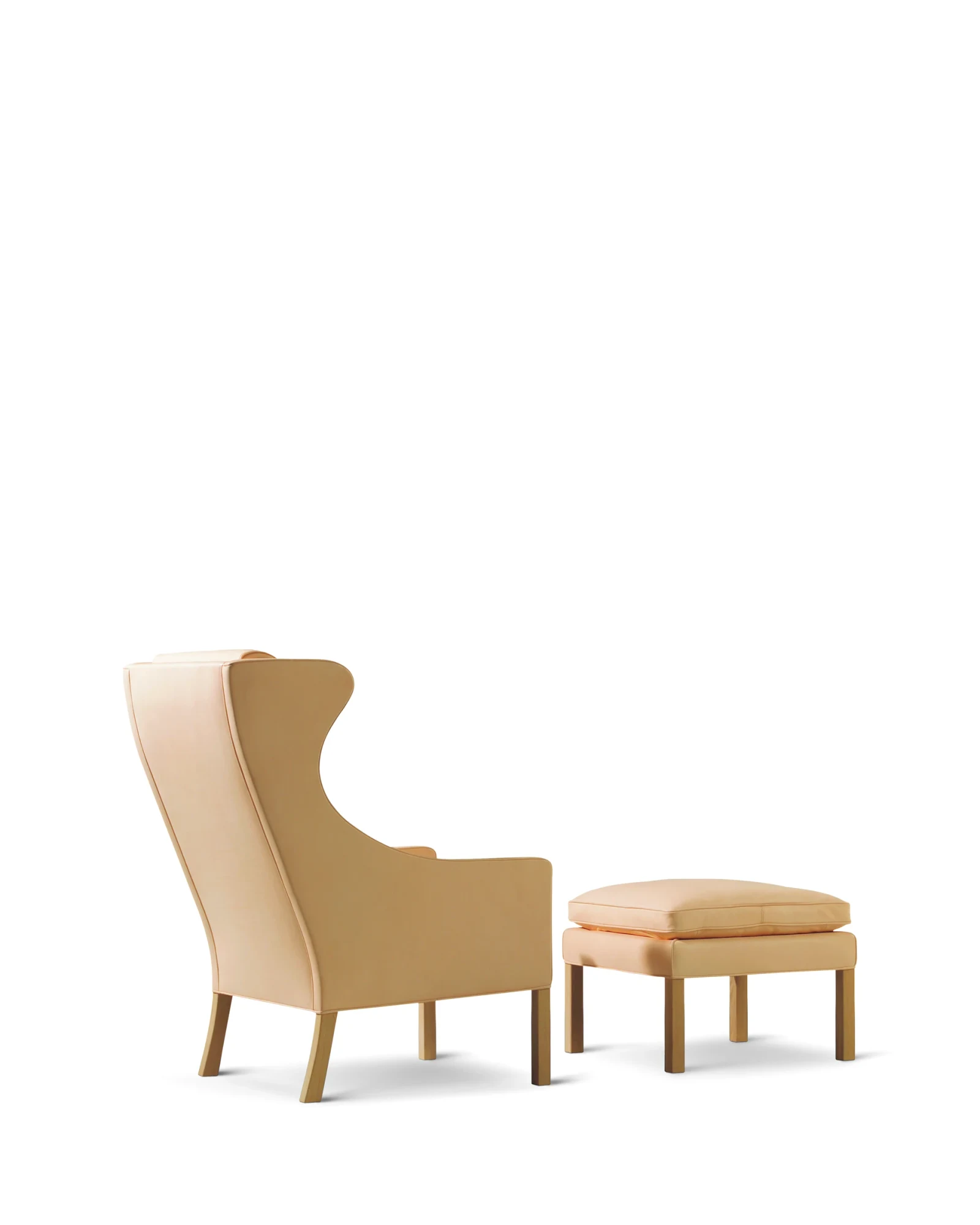 A wing chair with an ottoman on a white background