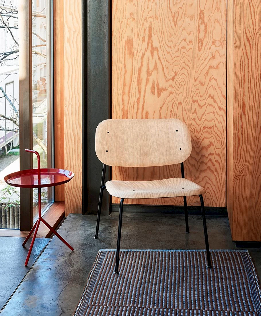 Chair with a steel frame beside a small side table and a window