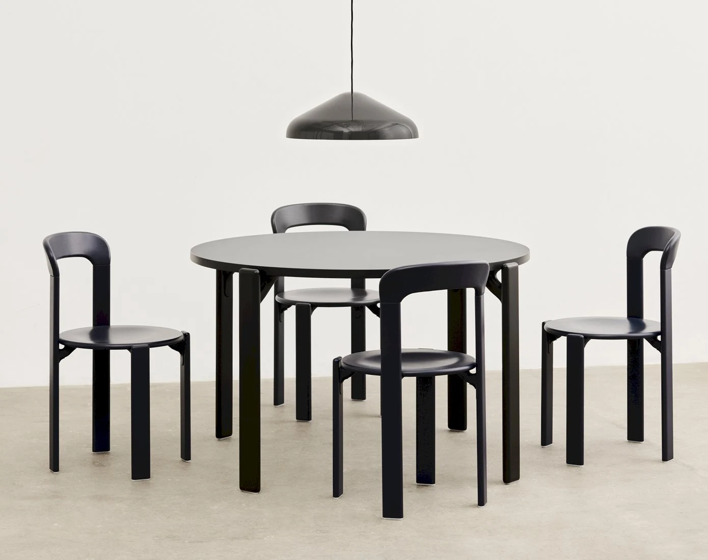 The Rey Table with chairs around it and a pendant lamp above
