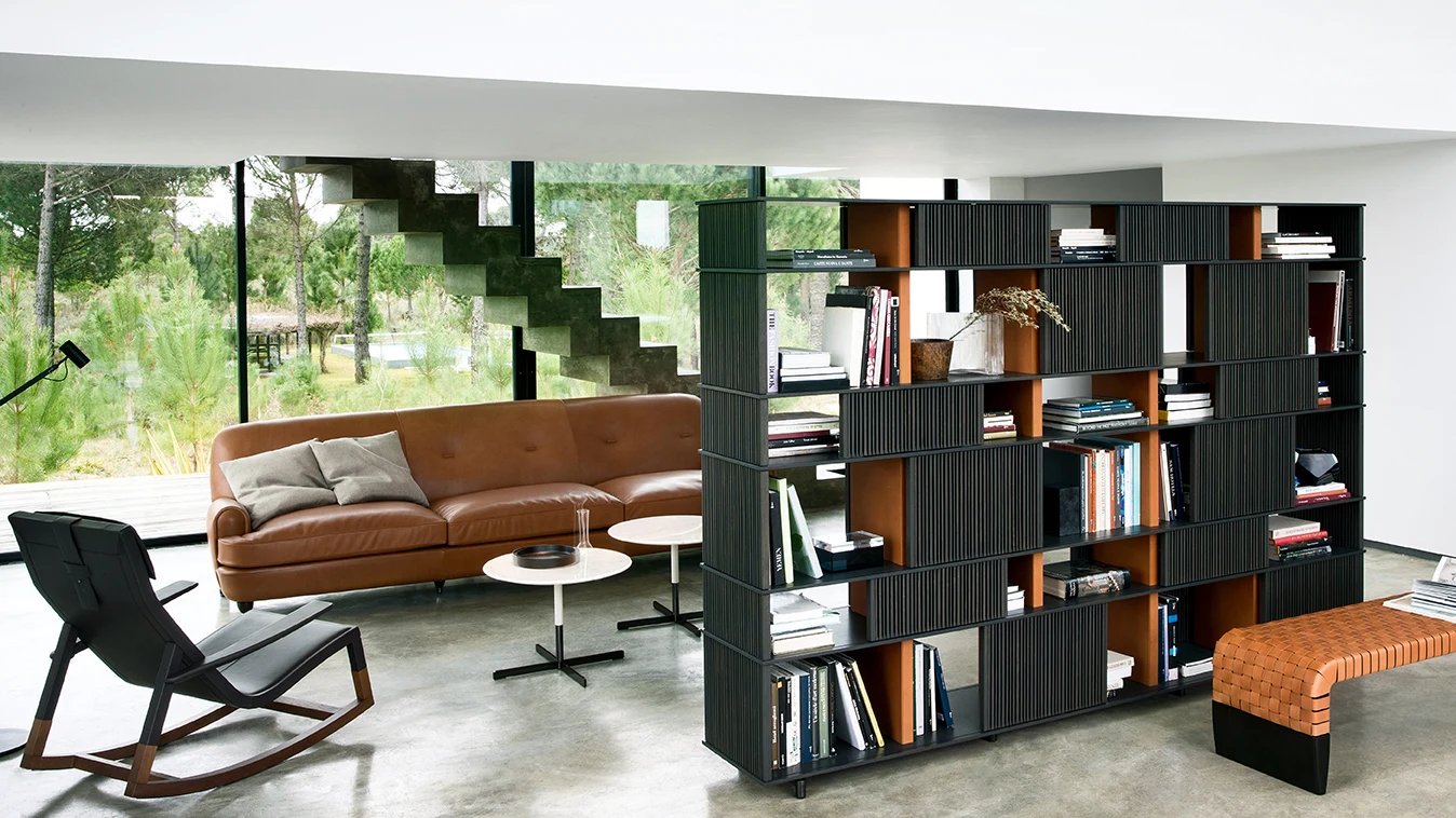 Lloyd freestanding bookcase used as a divider in a living room with a sofa, a rocking chair and a bench