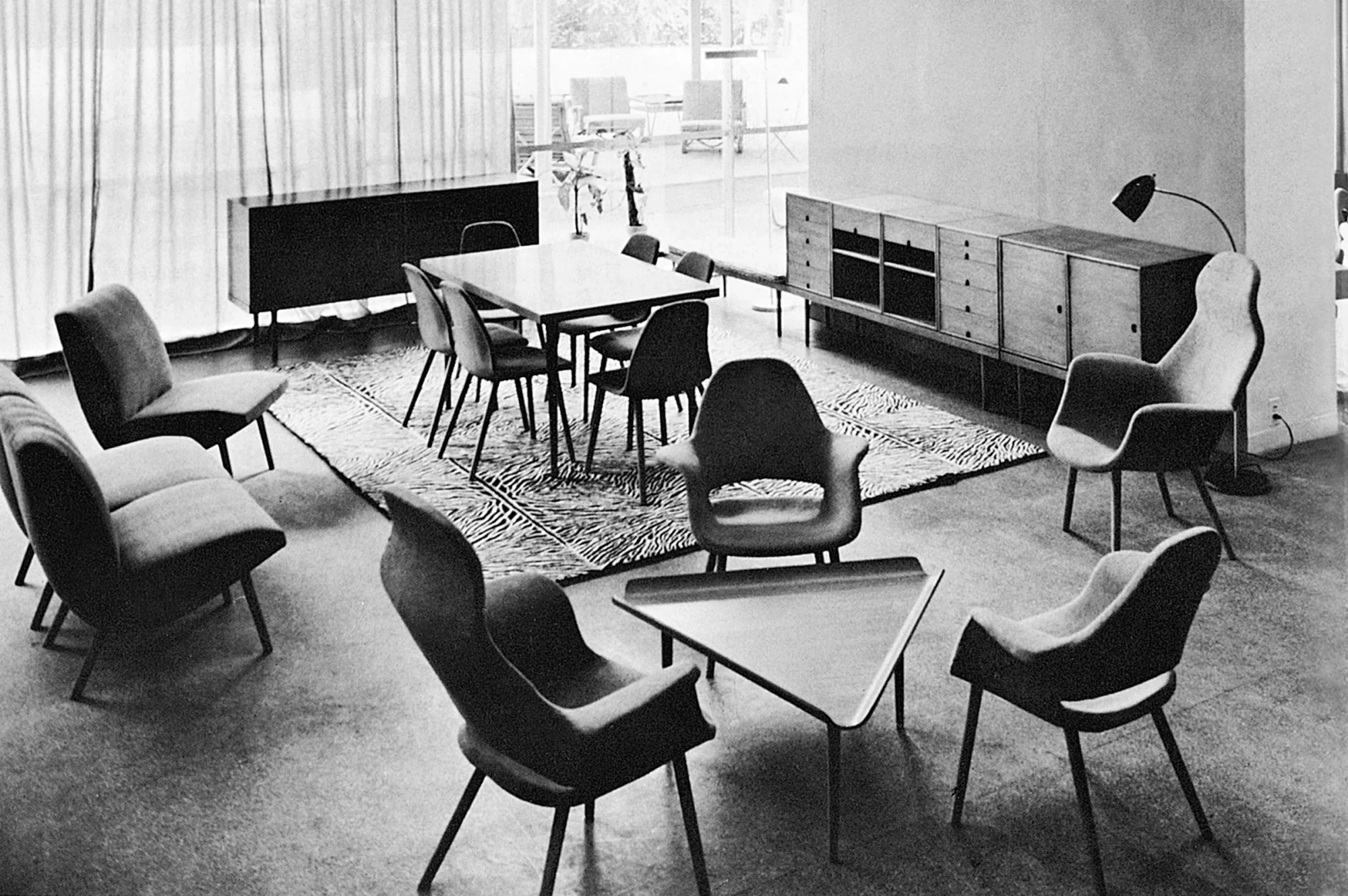 A monochrome photograph of a living space with armchairs and a table