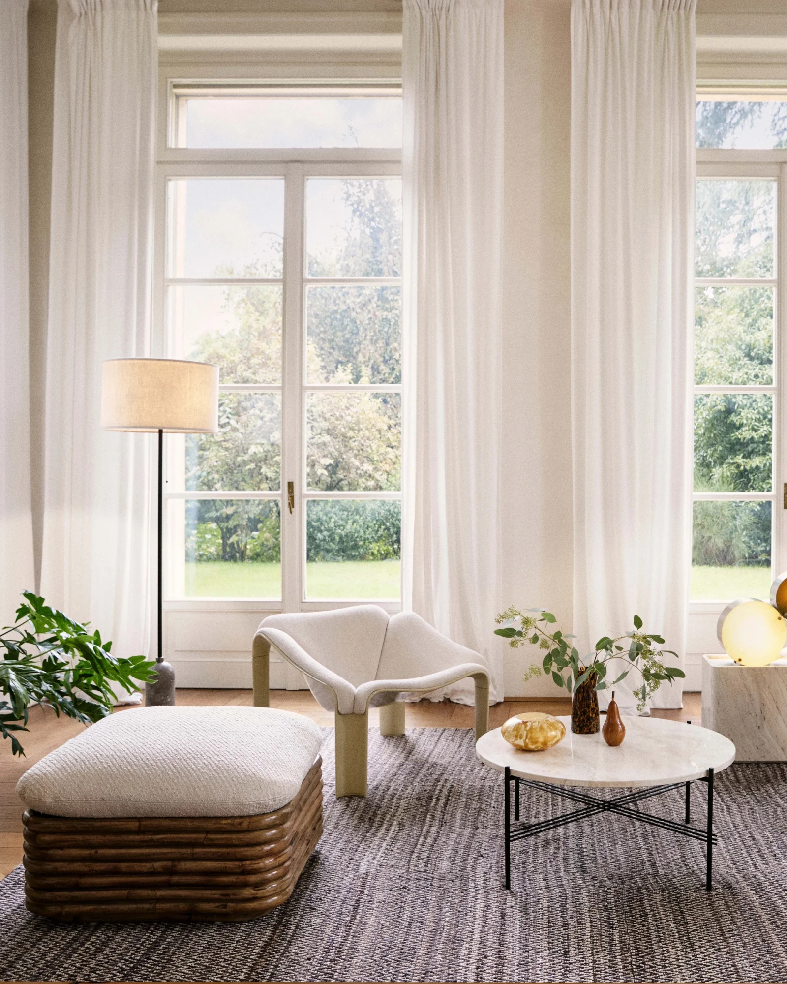 Round low table with a pale top and thin black legs with other furniture in a room