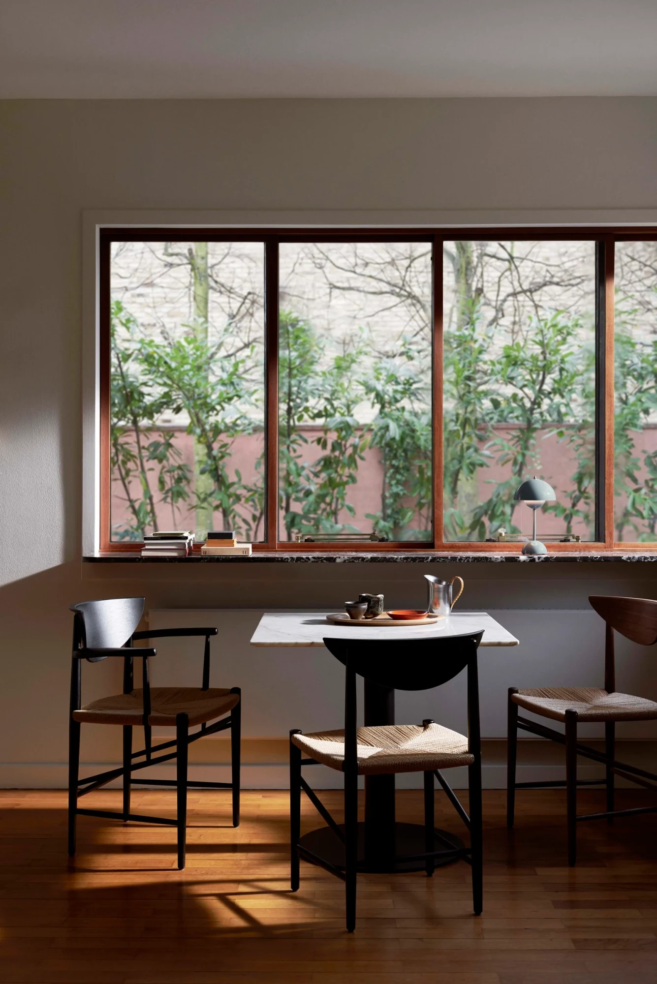 Armchairs with a woven seat around a small table in front of a window