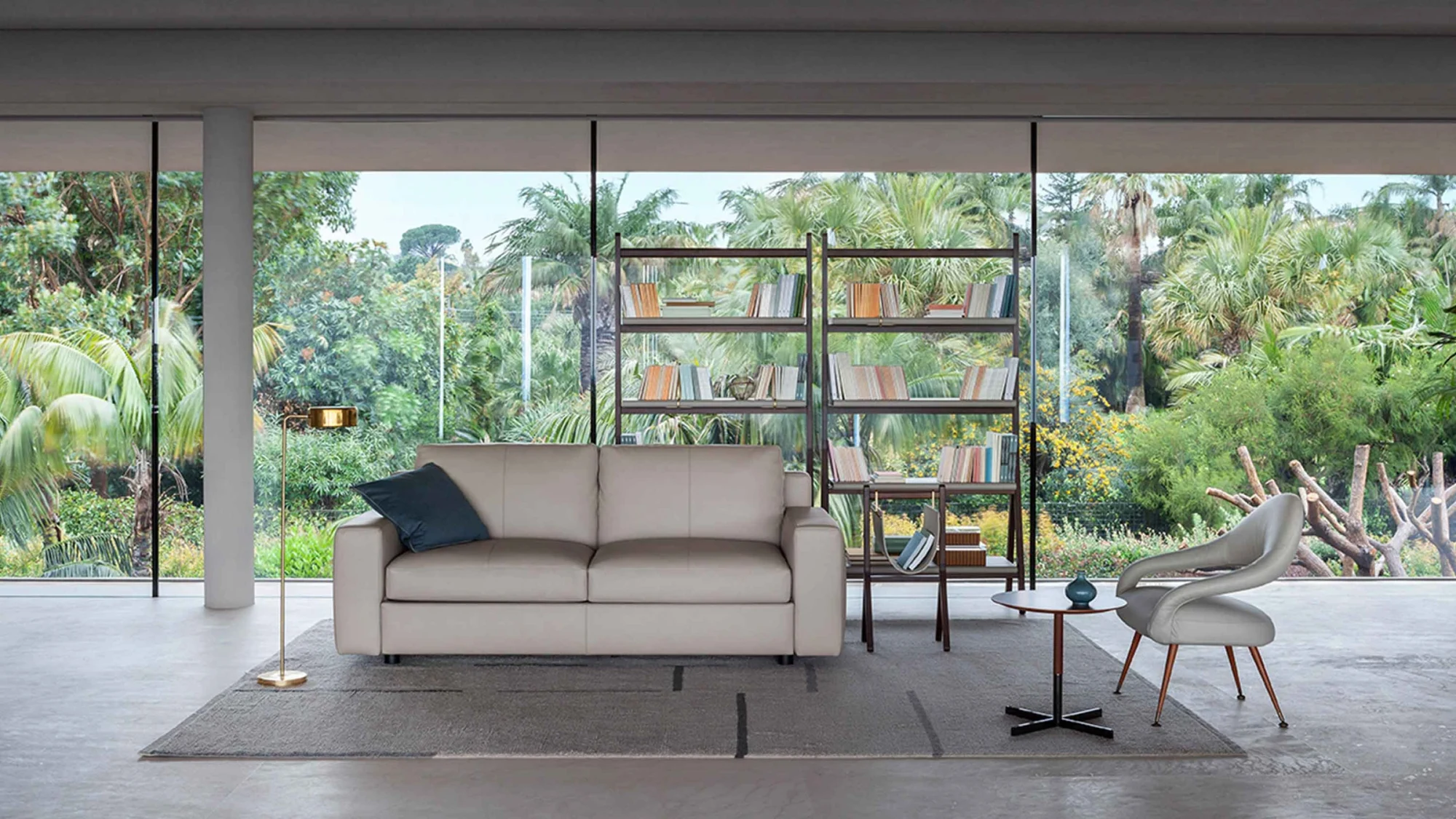 Massimosistema sofa-bed in a large room with tall windows, a floor lamp and an armchair