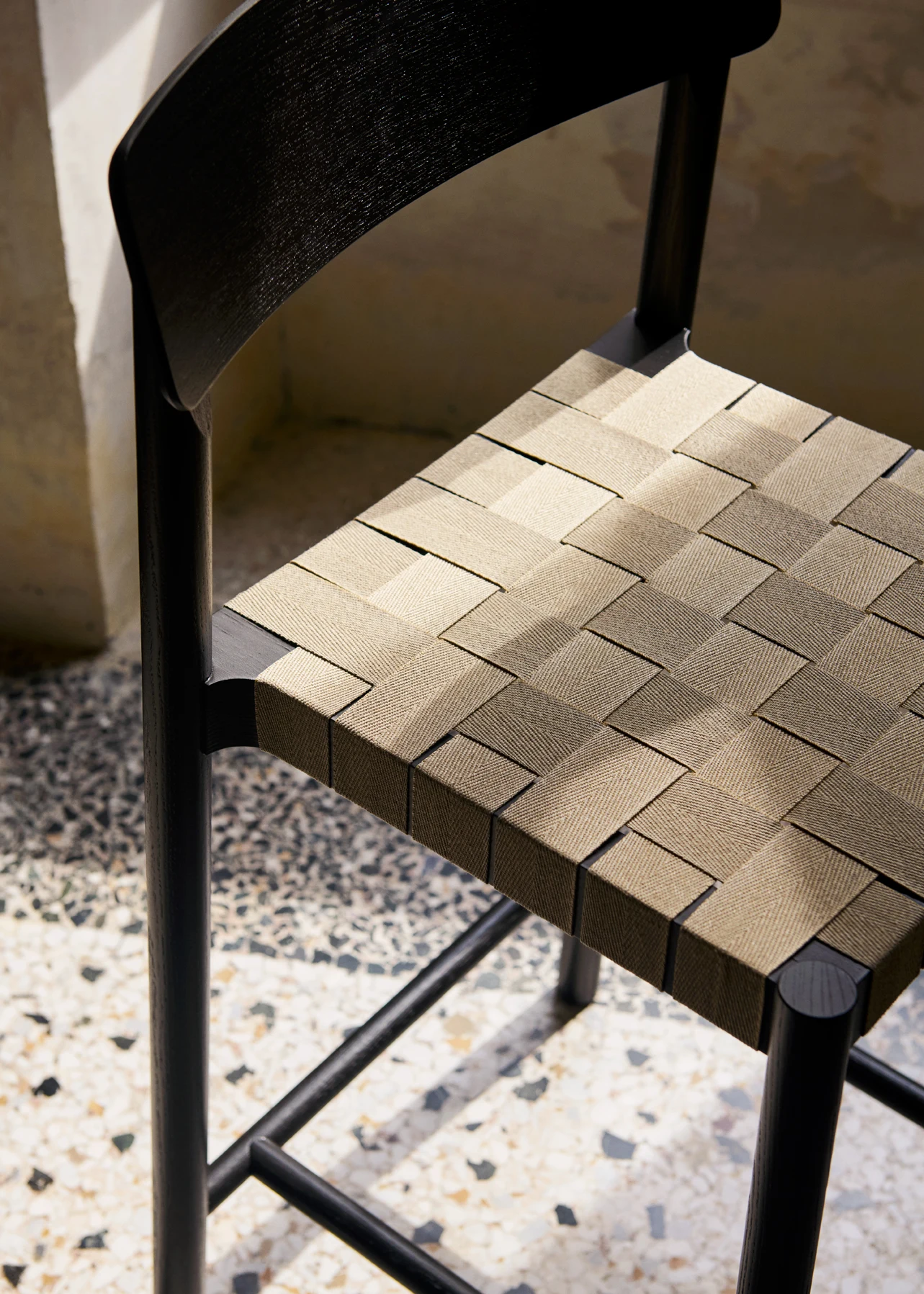 A close view of a webbing seat on a counter chair