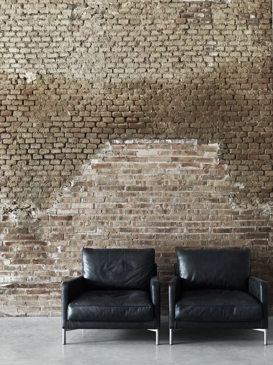 Fauteuils Dumas dans un intérieur aux murs de briques