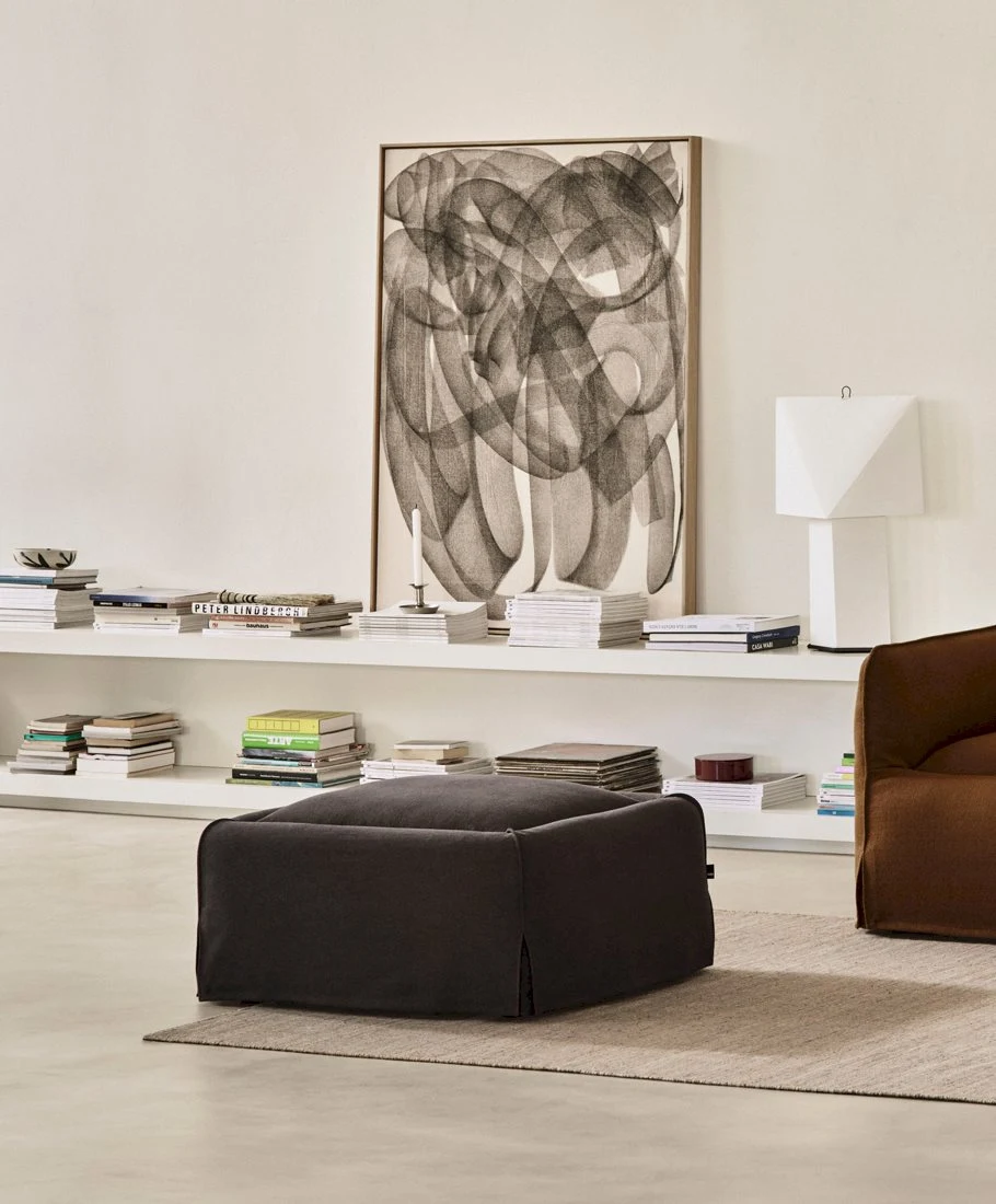 Mimi Ottoman in a room with shelves, a wall picture and a table lamp