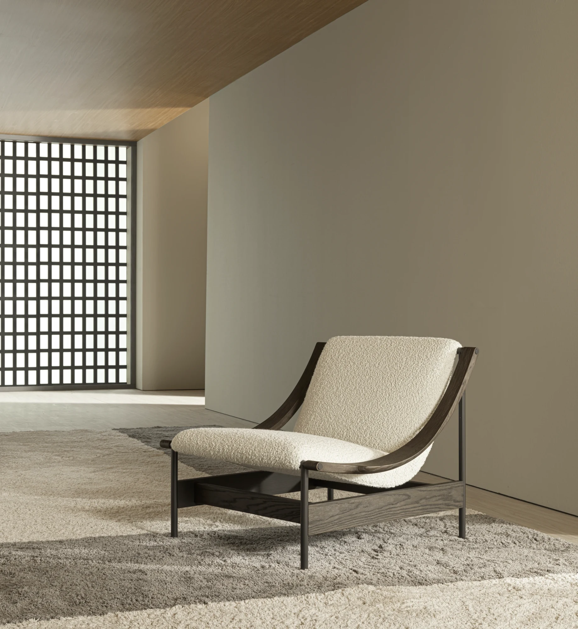 A Lia armchair with a light seat in a room with a lattice screen at the left and a plain wall behind
