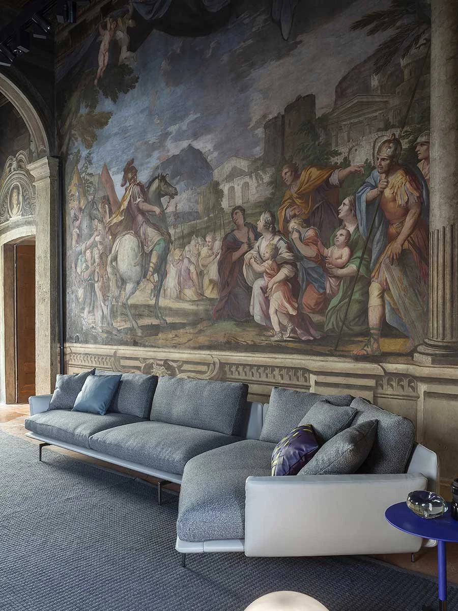 Blue sofa with a chaise end in front of a large painted mural