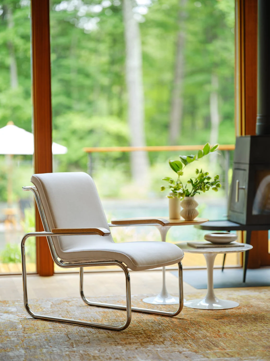 Una MB Lounge Chair accanto a un piccolo tavolo rotondo
