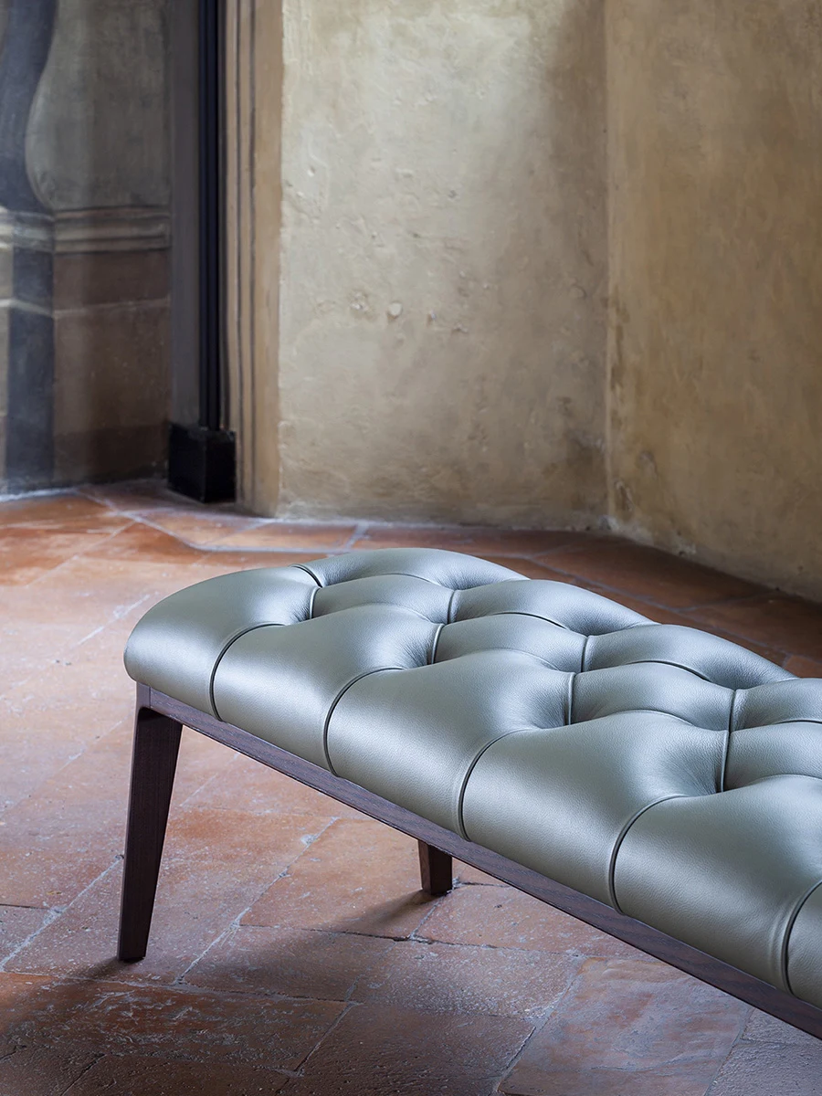 Buttoned bench seen from one end in a room