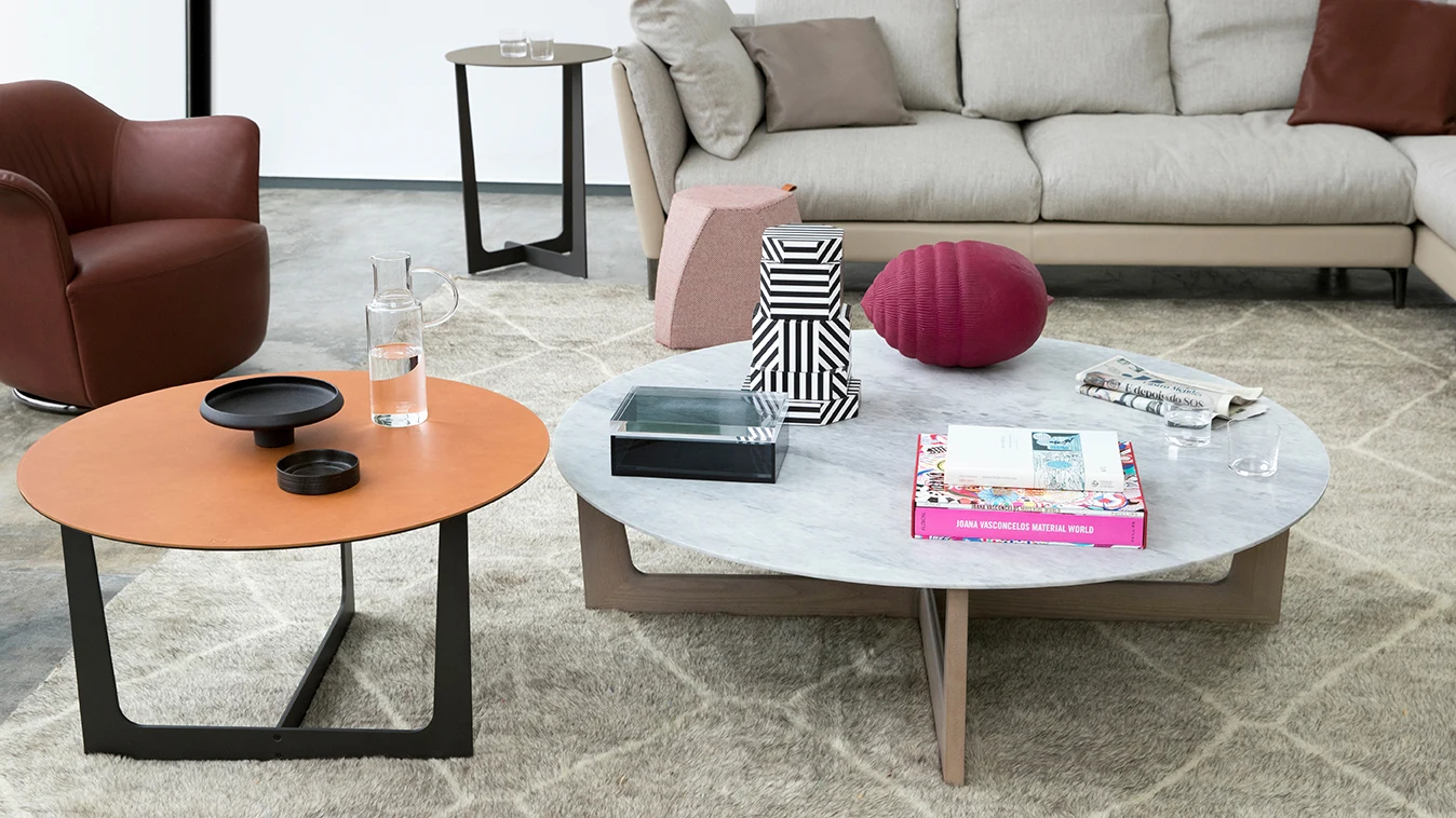Two round low tables in front of a sofa