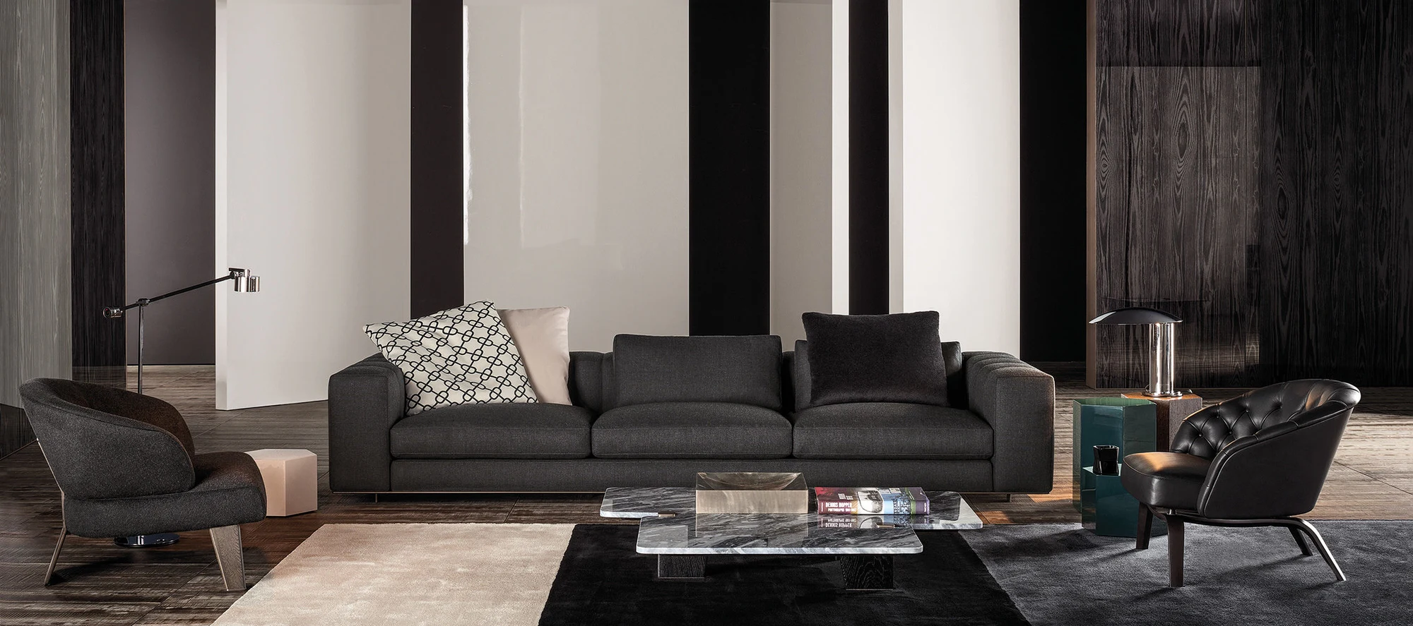 Sofa composition in a room with armchairs and low tables, official Minotti photo