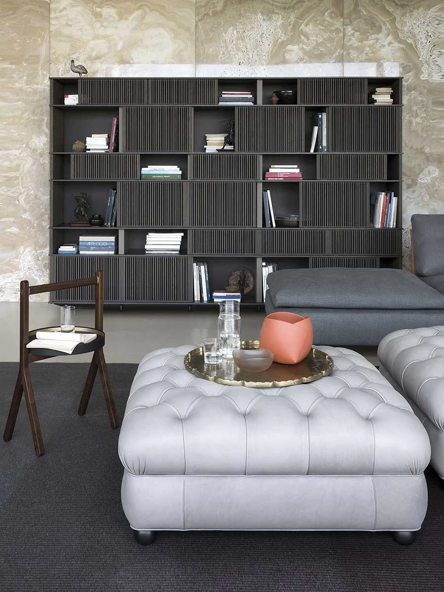 Pouf au premier plan d'un intérieur, avec d'autres meubles en arrière-plan