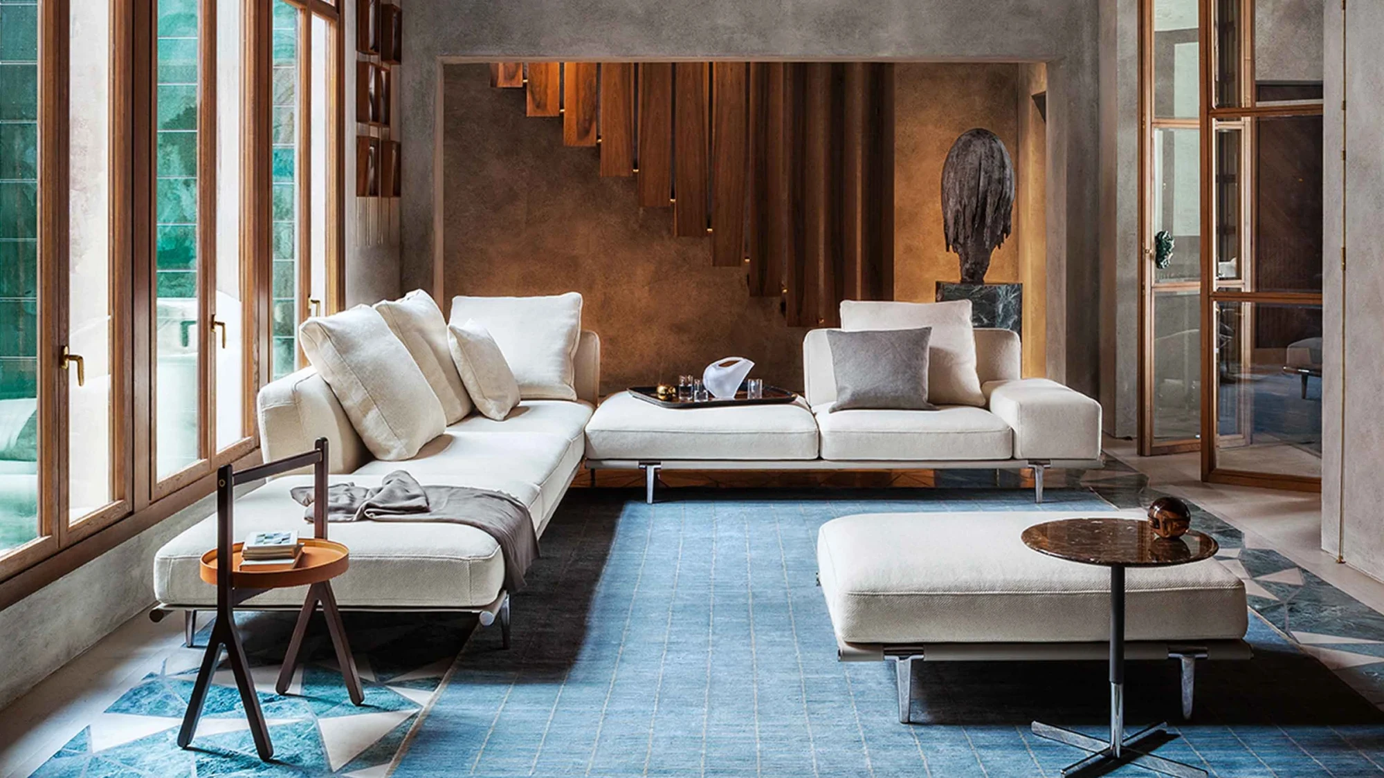 Sofa mit Hocker und einem kleinen runden Tisch in einem Raum mit Türen und einem Teppich