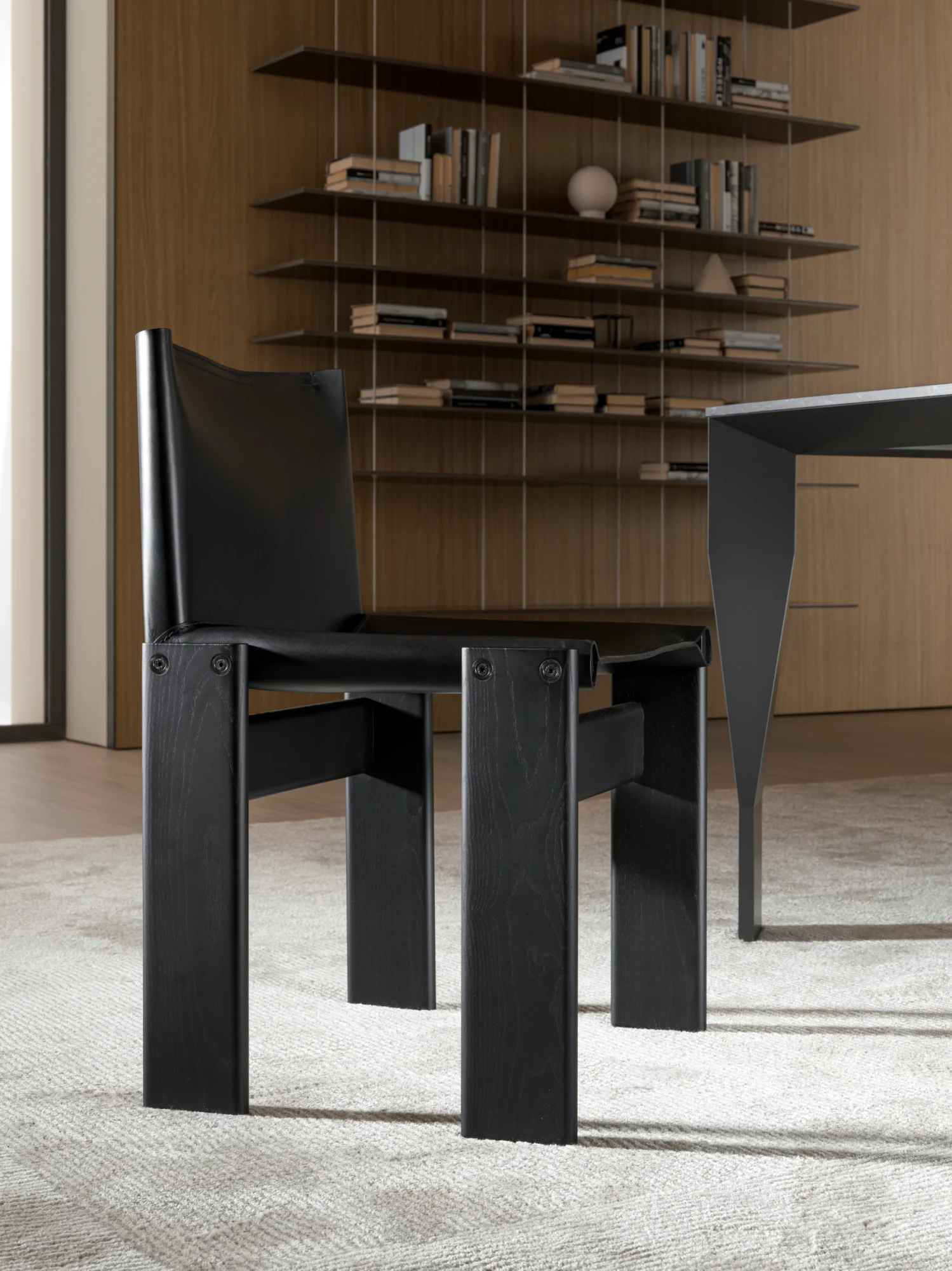 A black Monk chair with a shelving unit and a table edge behind it