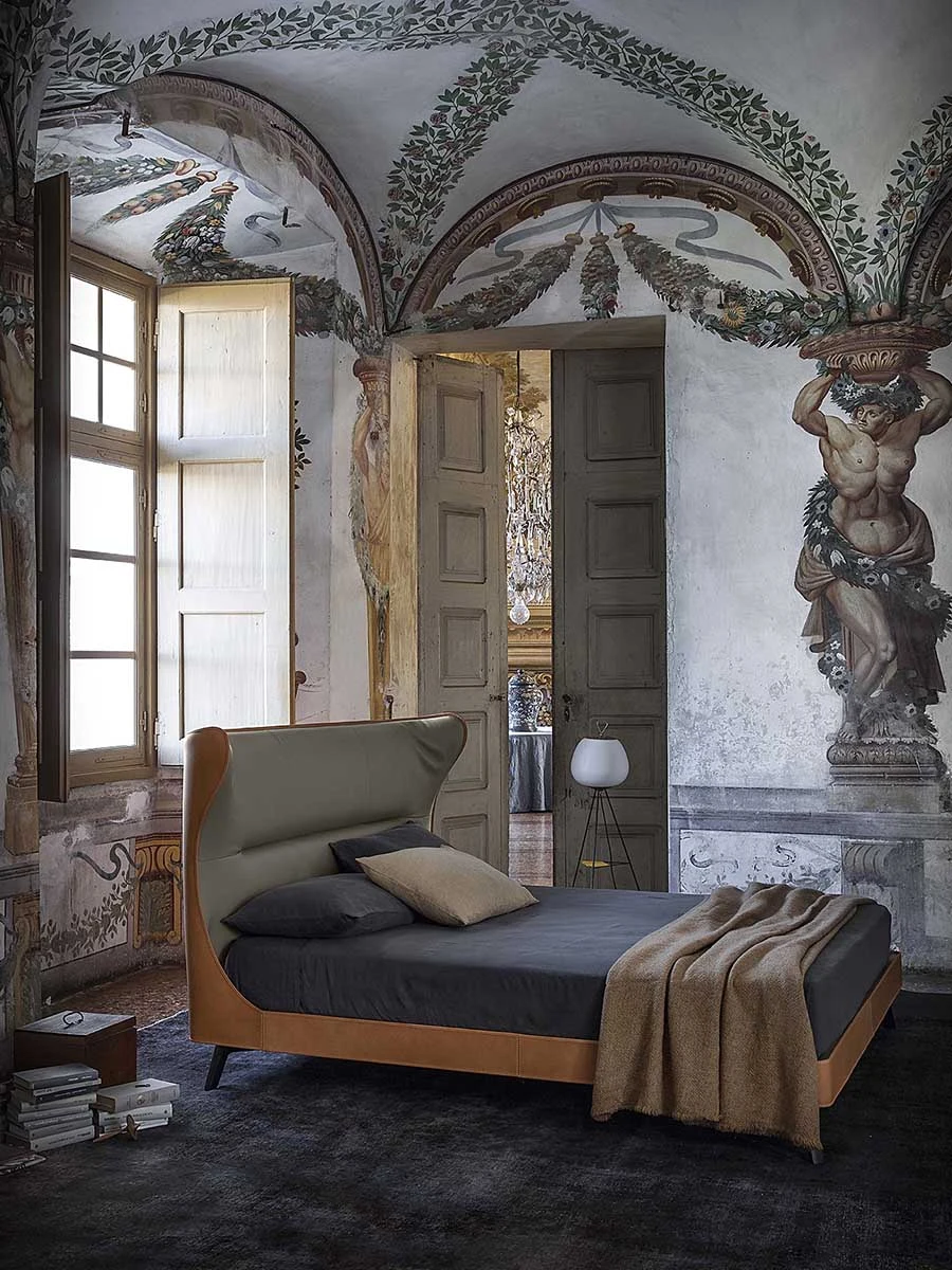 Cama con cabecero en una habitación con paredes y techo pintados