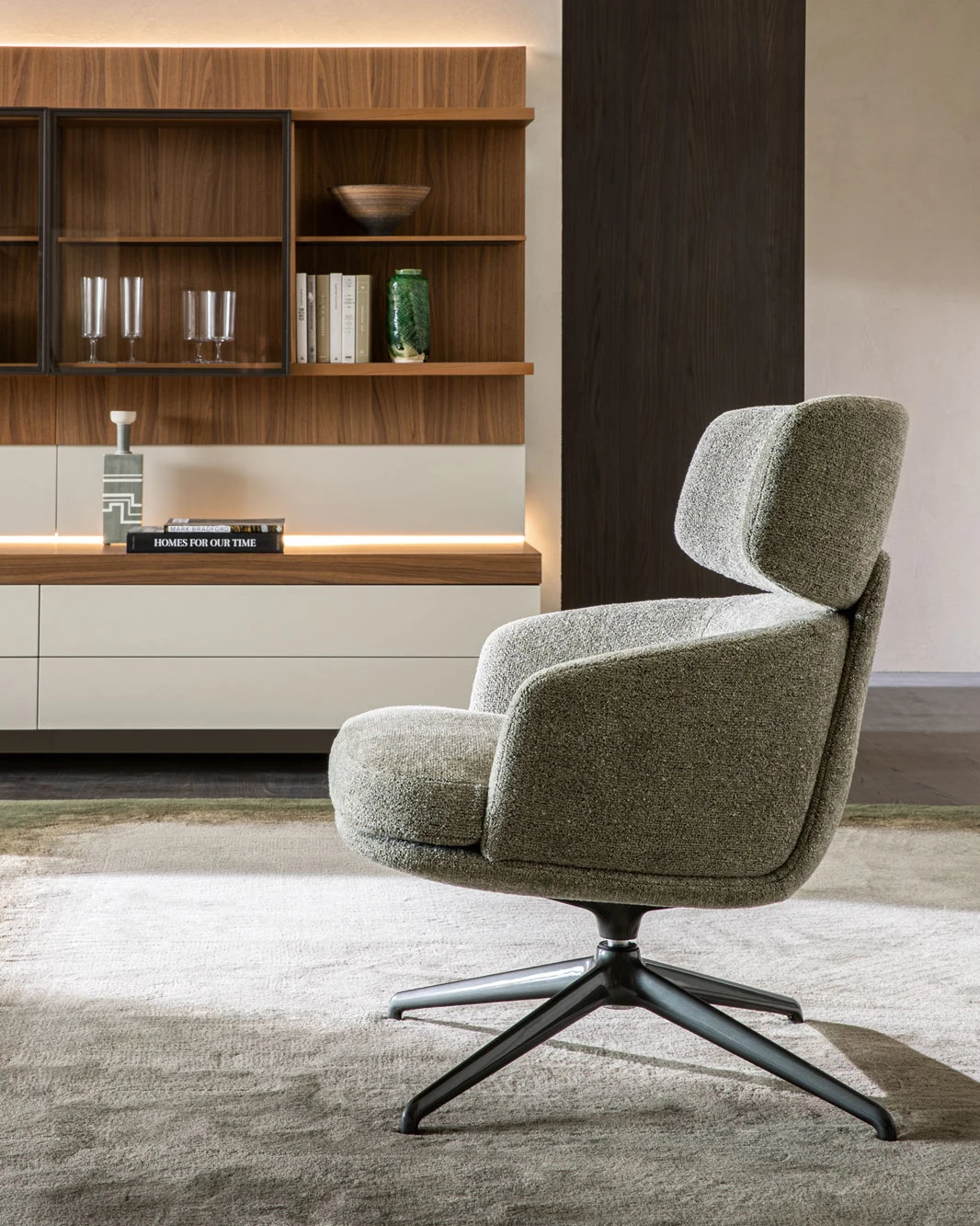 Piccadilly high-back armchair in front of shelving and a cabinet
