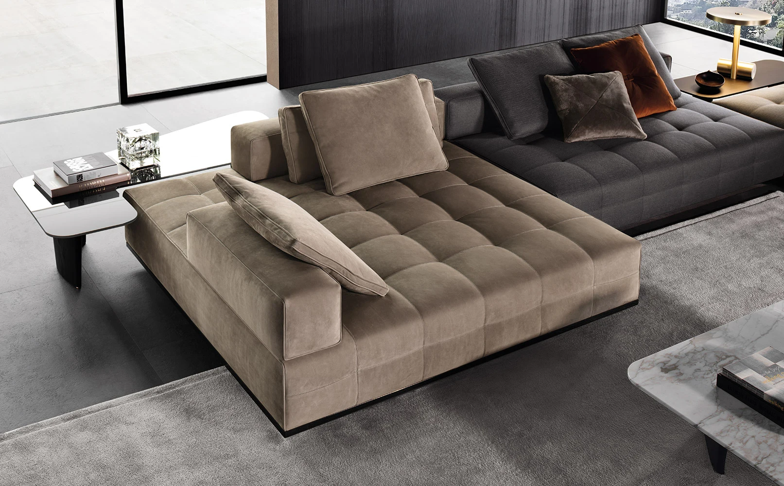 Chaise element with cushions beside a low table in a living room, official Minotti photo