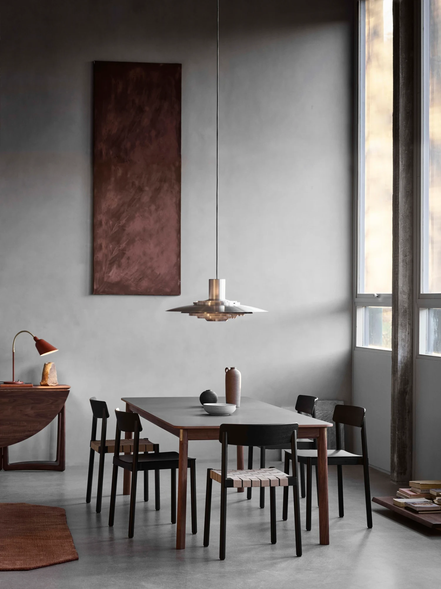 A dining table with four chairs in a high-ceilinged room