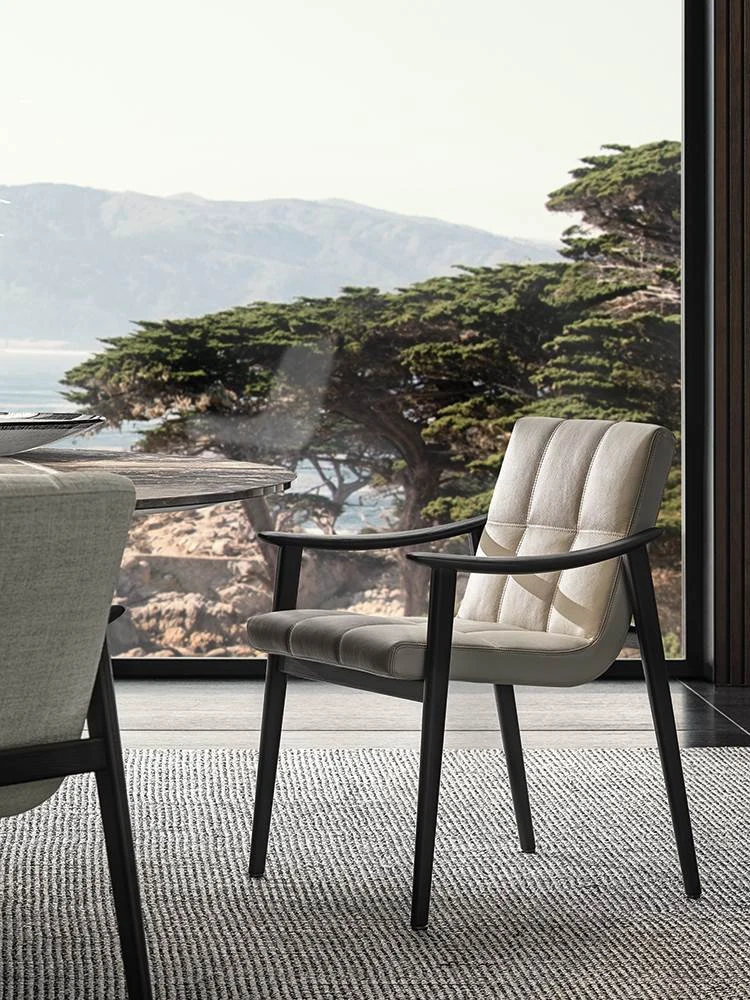 Dining little armchair with a quilted seat and a curved armrest, seen at an angle from the front