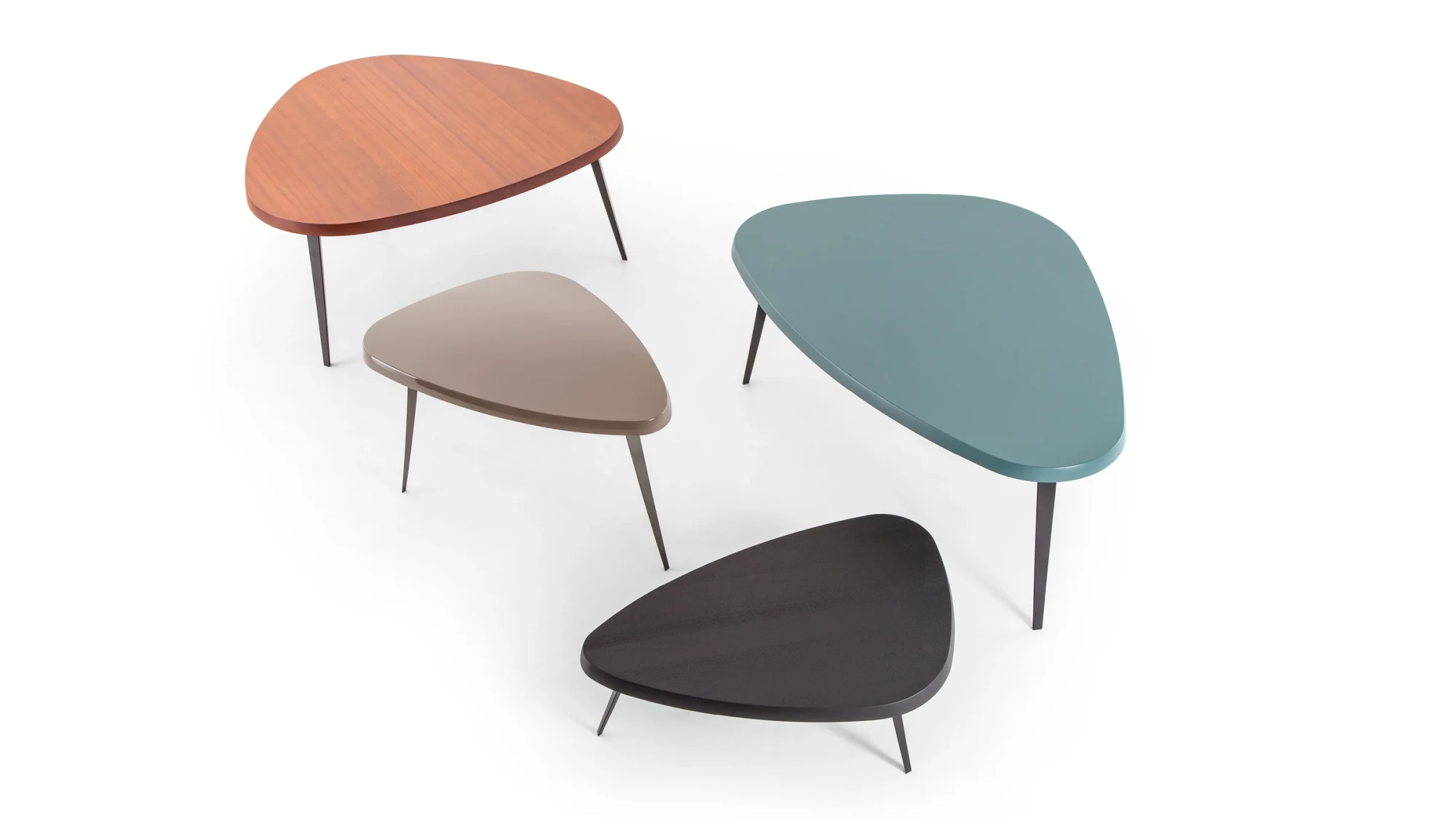 Four low tables with rounded triangular tops in different colours on a white background