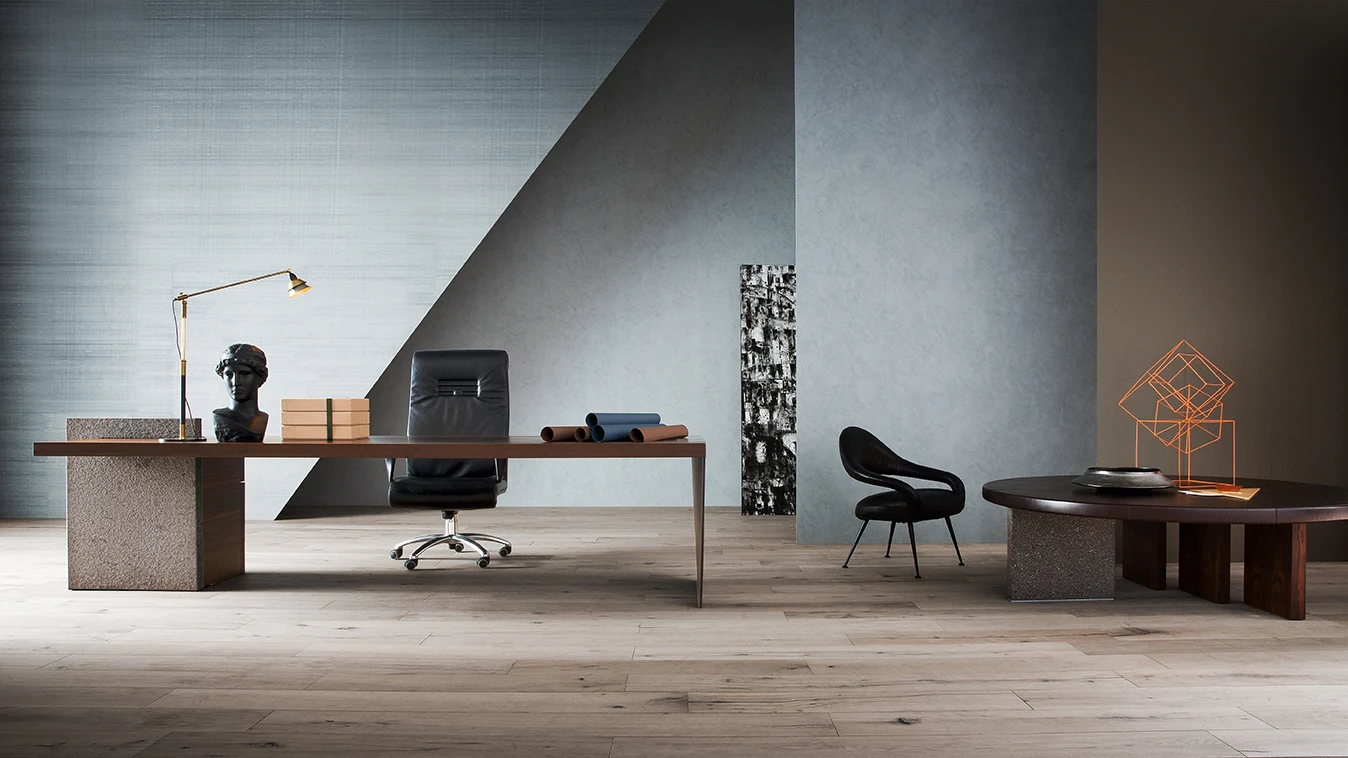 Desk with a chair behind it and a low table and armchair beside it in a room with a patterned wall