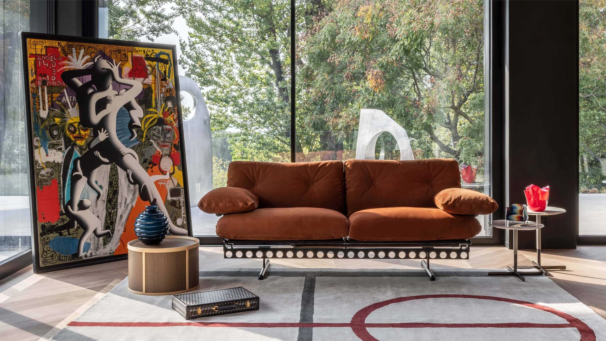 Sofa in a styled scene with a table at its right and an artwork at its left