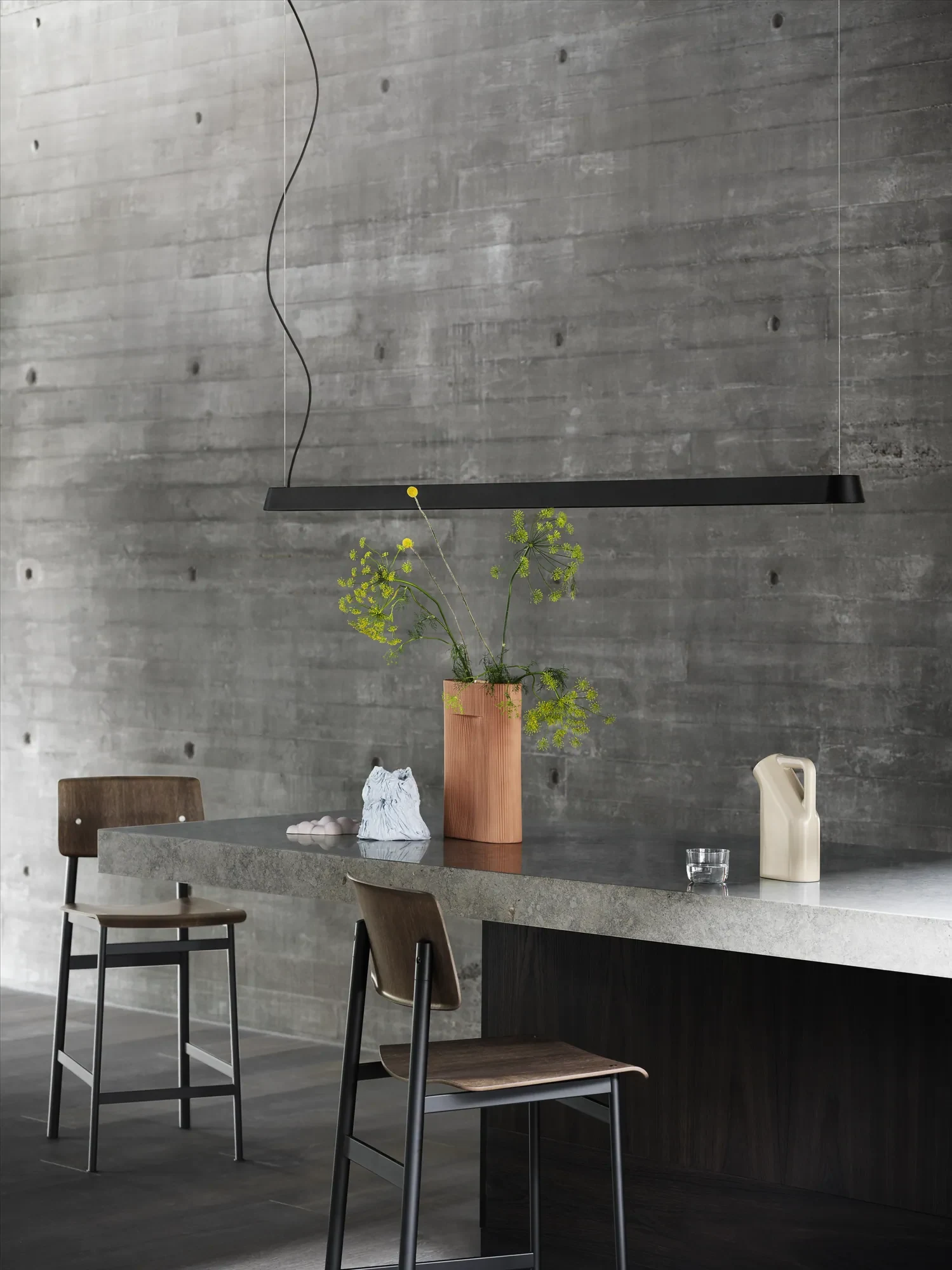 Loft counter stools at a counter beneath a long pendant lamp