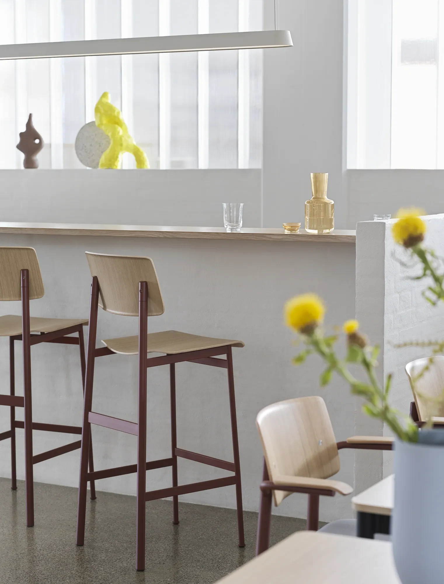 Loft bar stools at a bar counter with a long pendant lamp above
