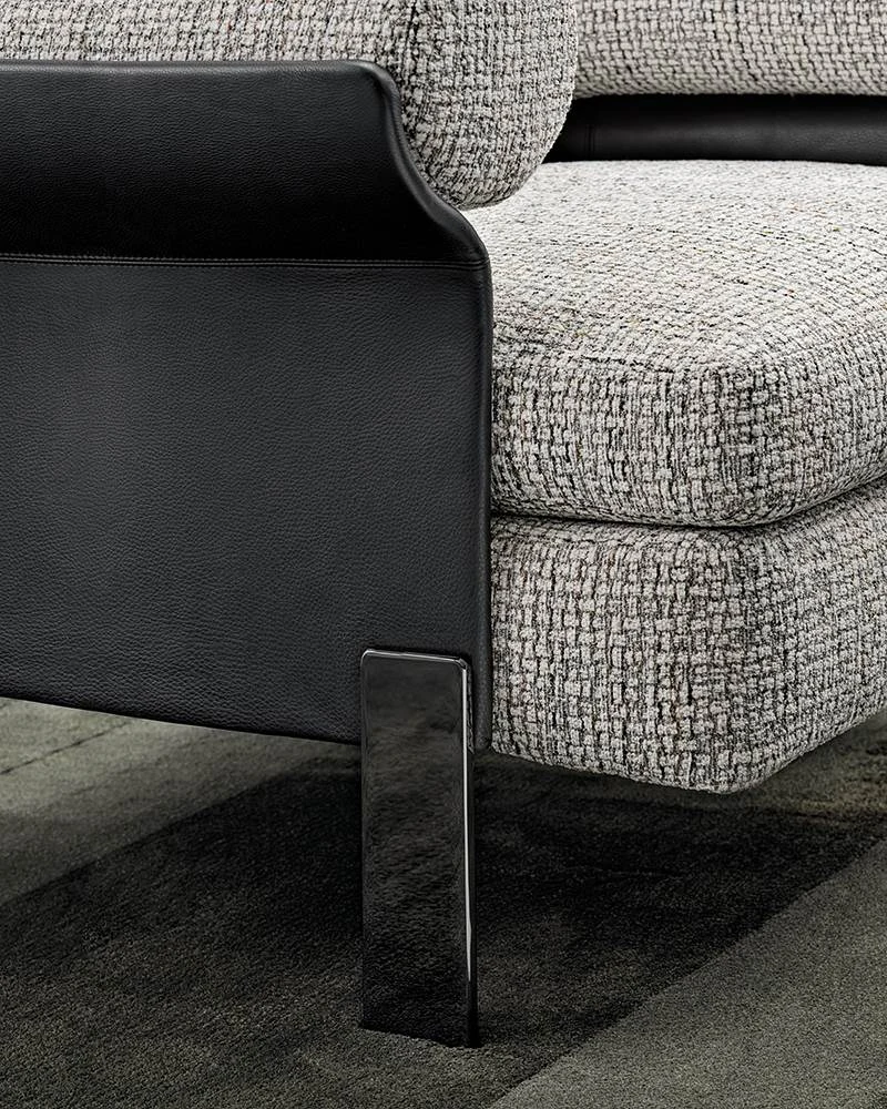 Close view of the shell edge beside the seat cushion and a metal leg, official Minotti photo
