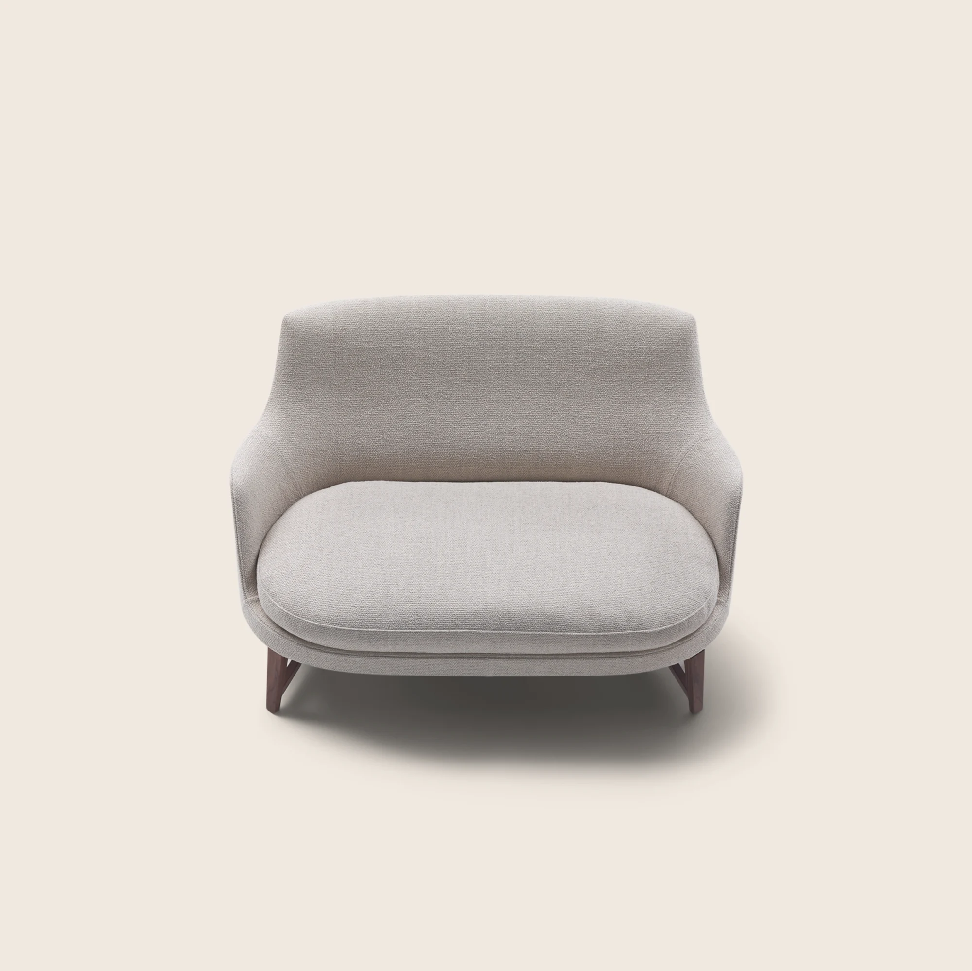 Three-quarter front view of the Guscio sofa on a wood base, plain background