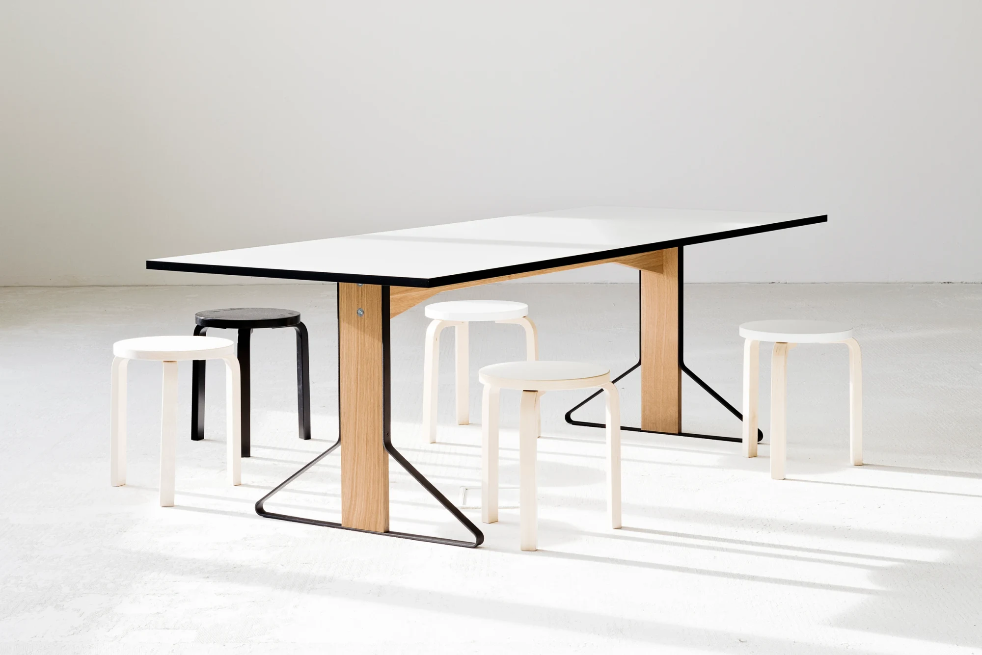 房间中的 Kaari Table,周围摆放着凳子
