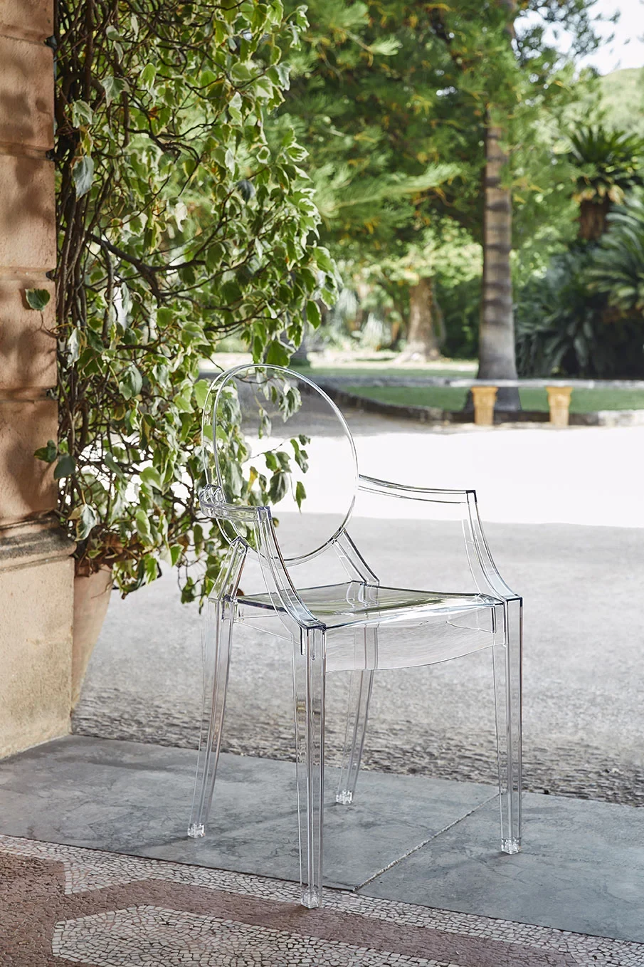 A transparent armchair standing by foliage outdoors
