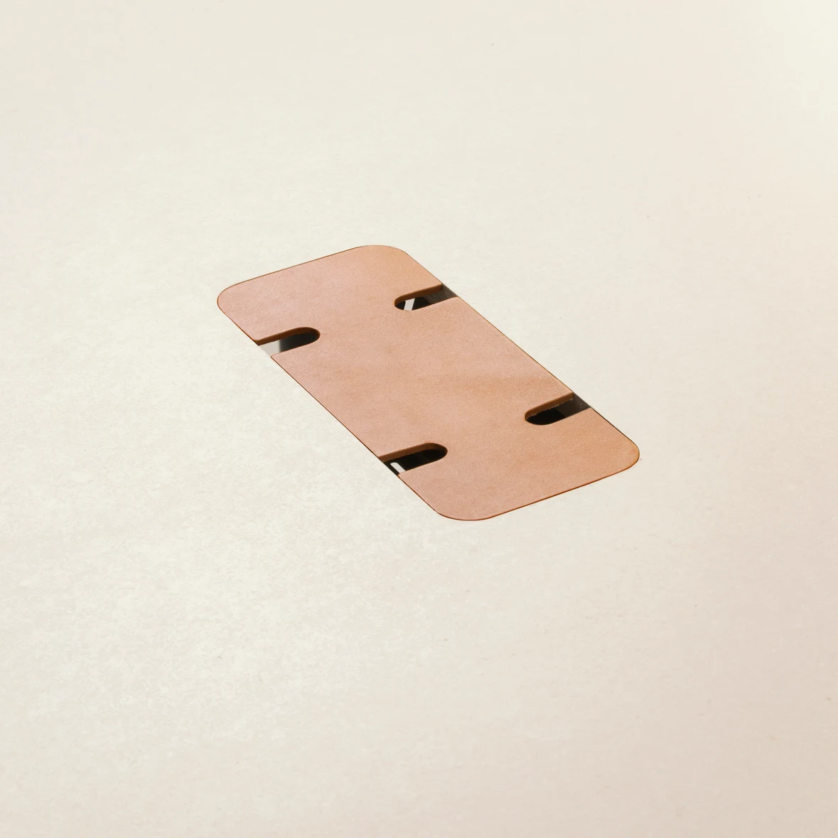 Close view of the cable cut-out in a light tabletop with a leather cover