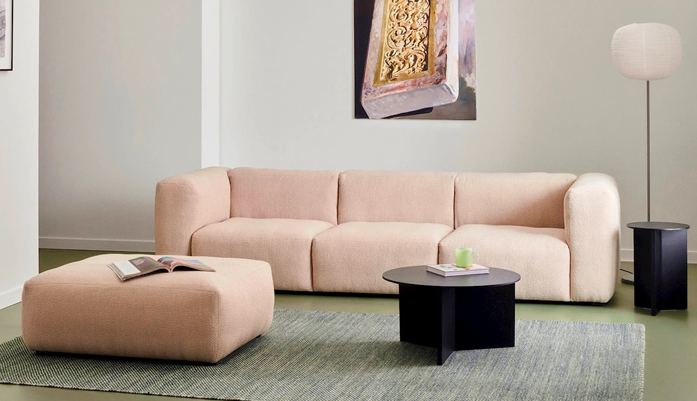 Mags Soft sofa with a pouf and a black round table in a room
